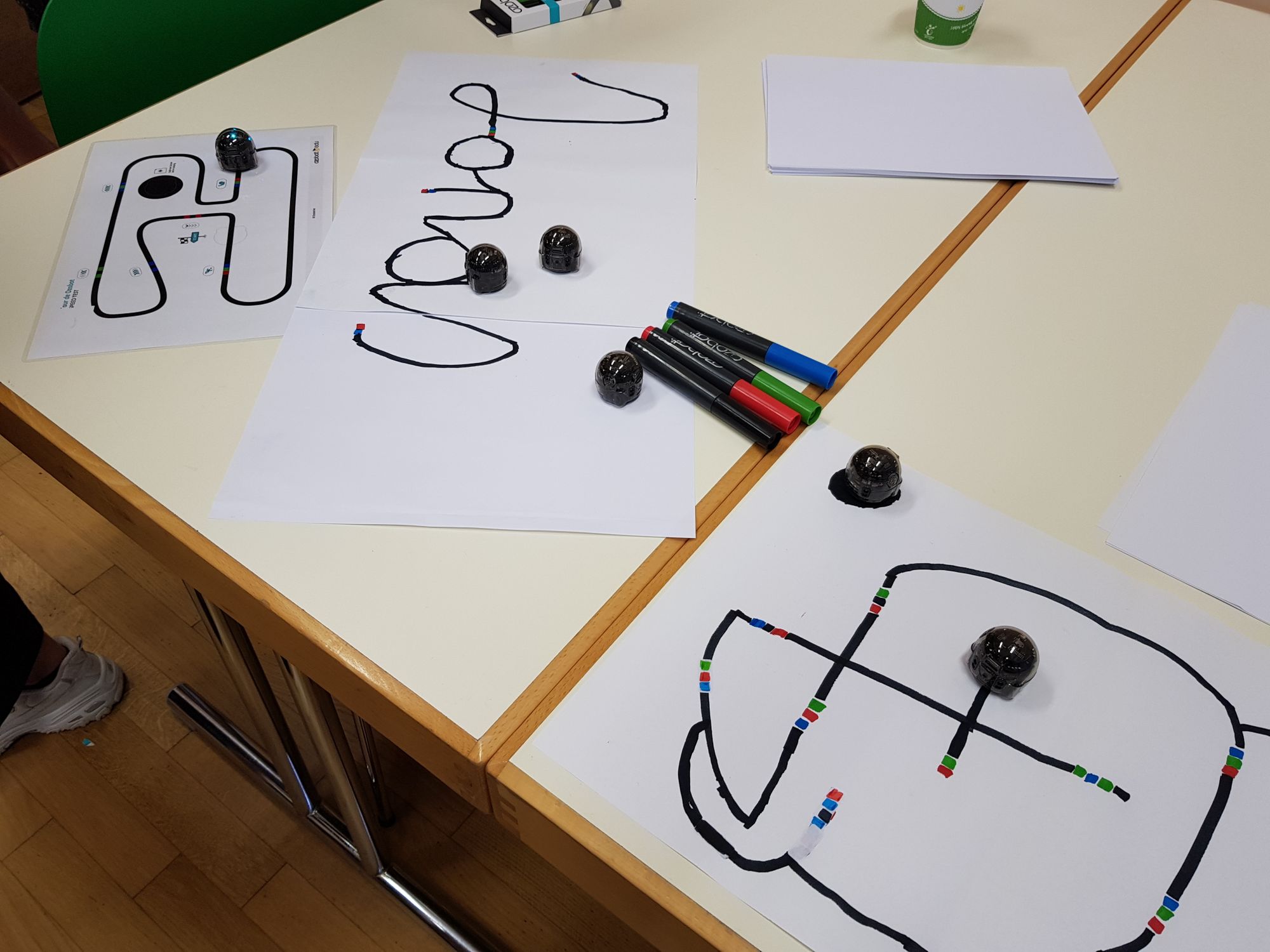 Schwarze Linien und Farbcodes, denen die Ozobot Roboter folgen. 