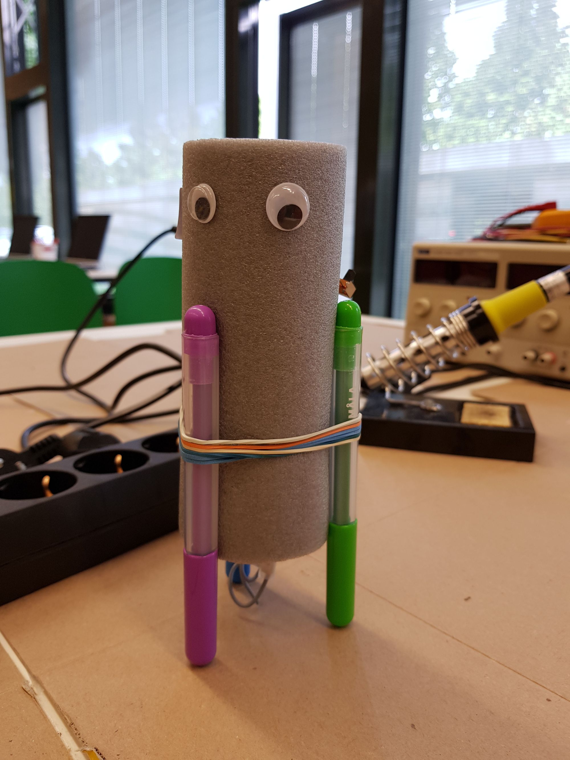 Wackelmaler der auf Filzstiften steht, mit Elektromotor und Unwucht. 