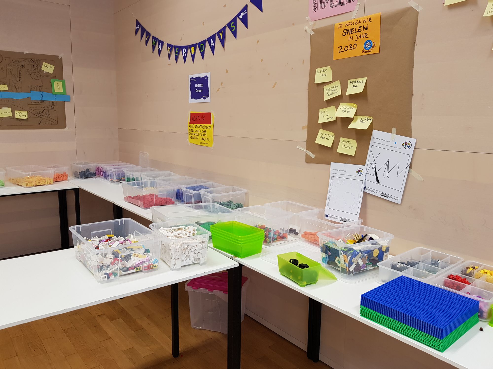 Boxen mit Lego® auf Tischen. 