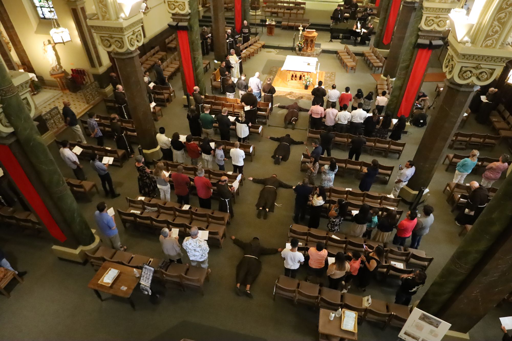 Br. Alwin, Br. Nathan, Br. Thomas and Br. José lie prostrate during their profession of solemn vows at St. Francis of Assisi Church in Milwaukee on July 26, 2021