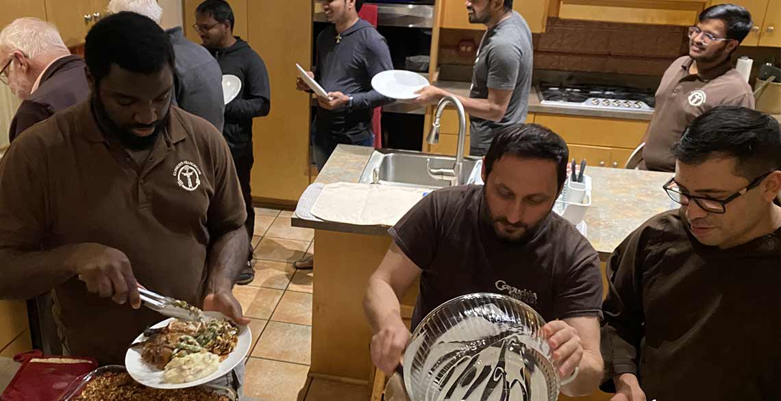 Capuchin friars in the kitchen preparing a meal at St. Clare Friary.