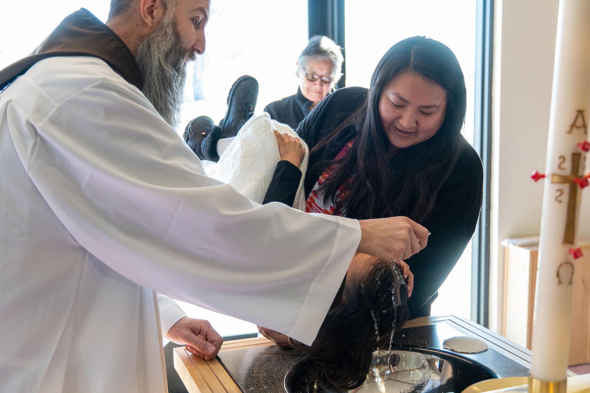 Br. Mike Dorn baptizes an infant at St. Dennis Church in Crow Agency, Montana.
