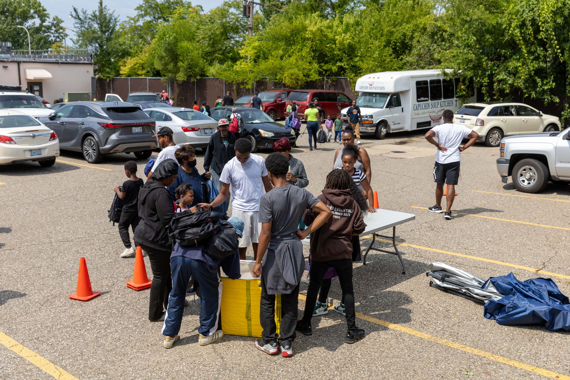 A color landscape high-angle photo of backpacks being distributed to families at the Conner Capuchin Soup Kitchen location.