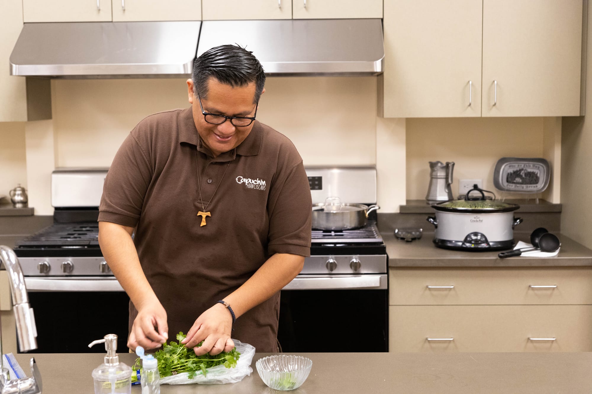 David at the kitchen island preparing herbs that will be part of a community dinner at the Monastery.