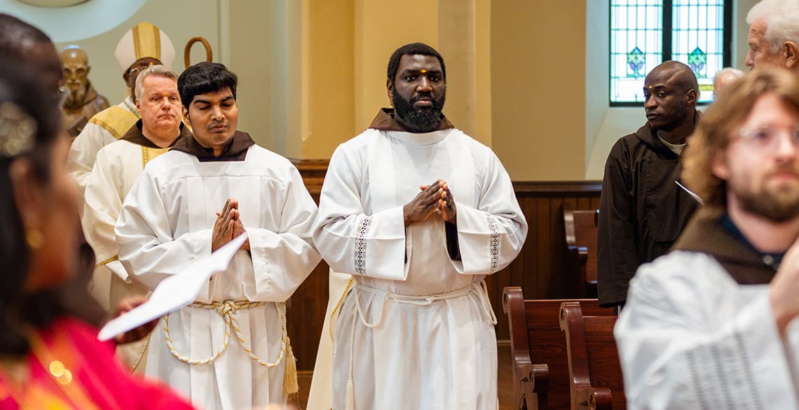 Friars Alwin Anthonysamy (L) and Baudry Metangmo (R) process into St. Bonaventure Chapel in Detroit for their Ordination to the Transitional Diaconate.