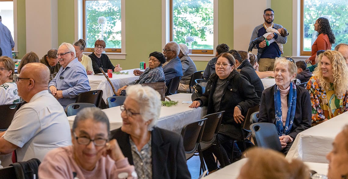 Photo of parishioners seated at tables inside the St. Francis Capuchin Center in Milwaukee.