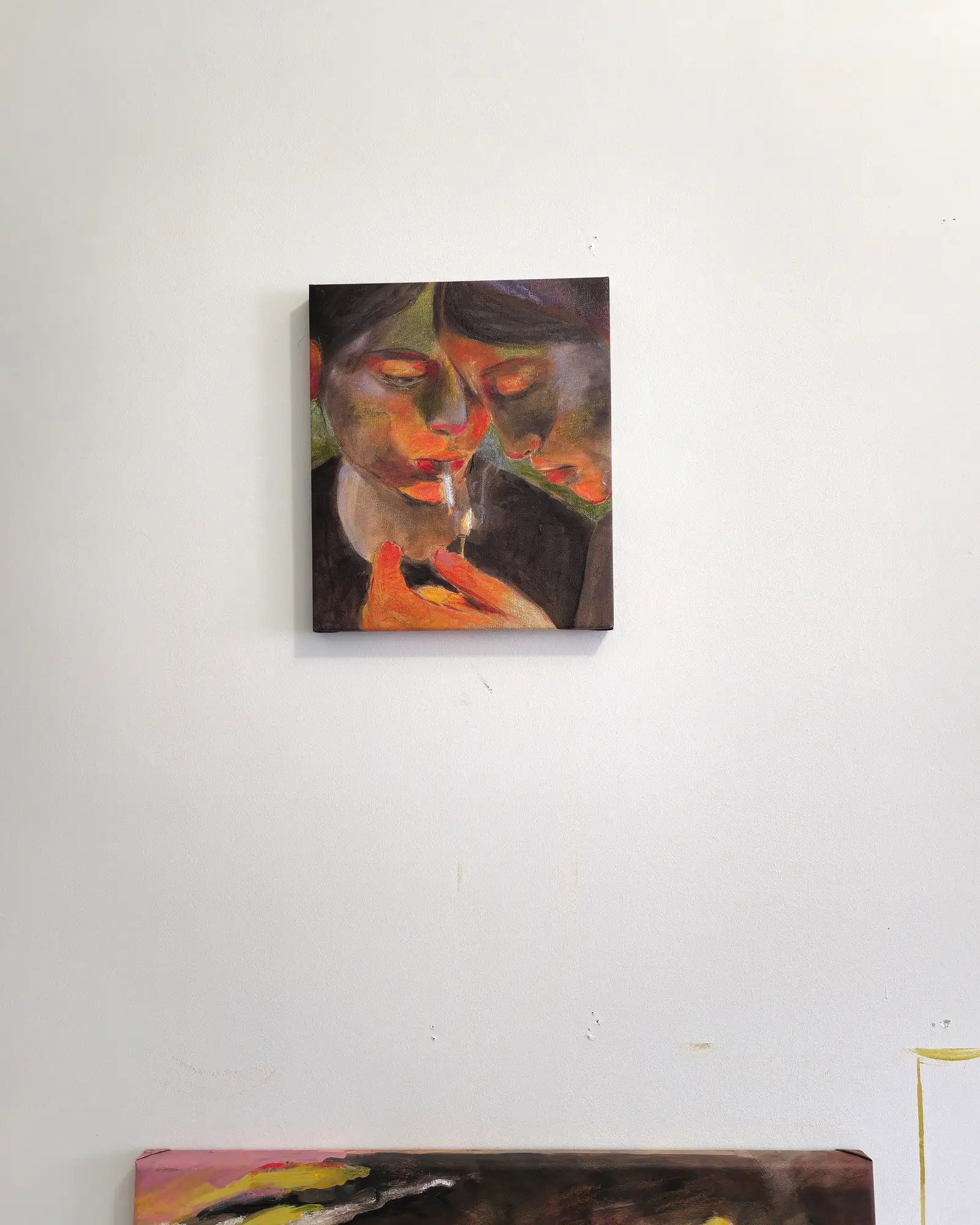 On the studio wall in Lisbon: an intimate moment flickers between two figures, captured in half-light and emotional proximity.