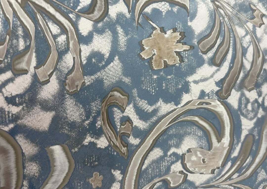 Close-up of Bety Krňanská’s 'Bloomers,' showing finely etched metallic floral details on a blue car hood surface, blurring the line between decoration and material aggression