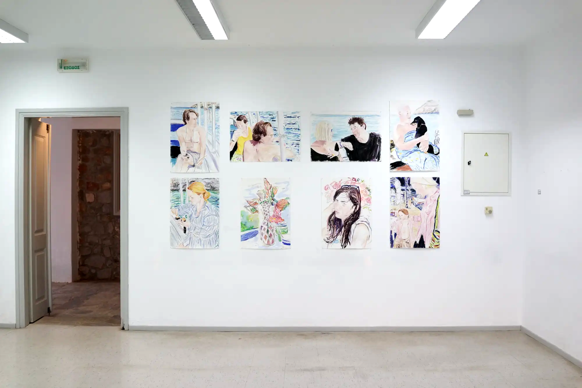 Exhibition view of Hydra School Projects 2025, Lithos Lethe. A wall of drawings by Billy Sullivan depicting portraits of friends, people by the sea, a dog, and still life flowers — colorful impressions from life on Hydra Island.