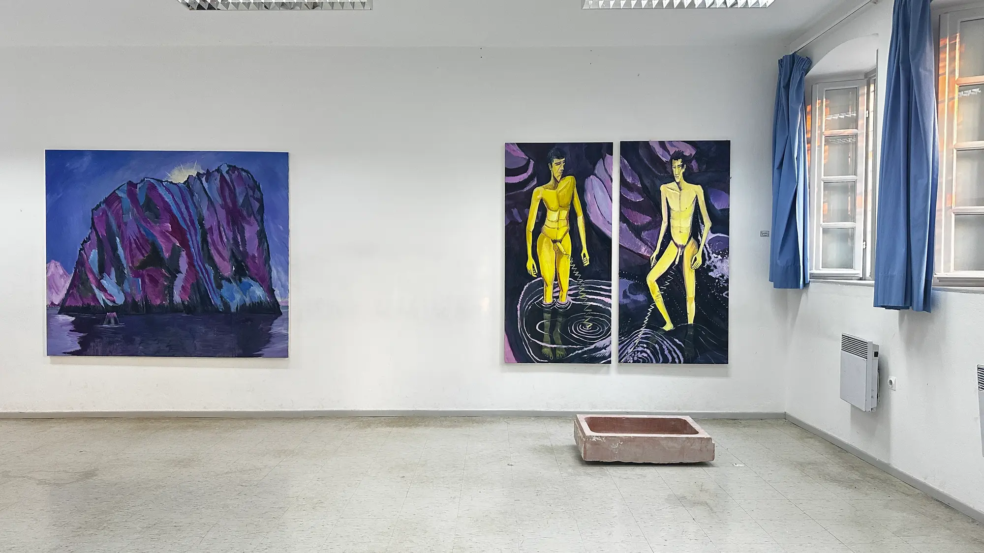 Exhibition view of Hydra School Projects 2025, Lithos Lethe. Paintings by Konrad Zukowski — a violet cliff landscape and diptych of yellow figures — displayed with a marble fountain sculpture by Dimitrios Antonitsis inside the former Hydra school building, Greece.