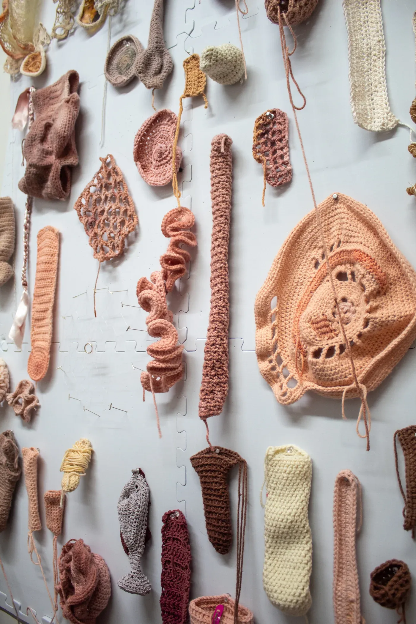 Ophelia Arc wall installation of crocheted textile fragments in flesh tones resembling organs and skins