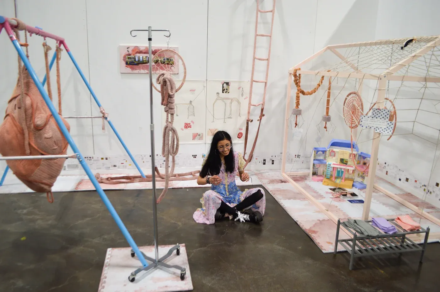 Ophelia Arc installation with swings, textile ropes, and house-like structures, combining playground and surgical atmosphere