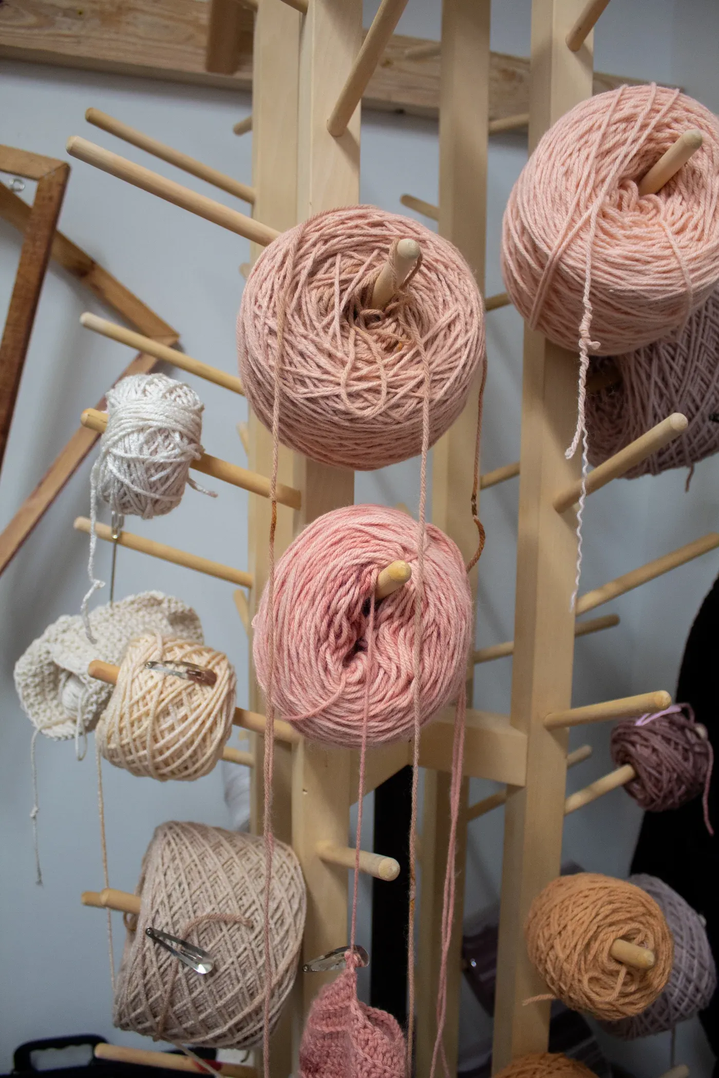 Ophelia Arc yarn rack with spools of pink and beige yarn prepared for crochet sculpture