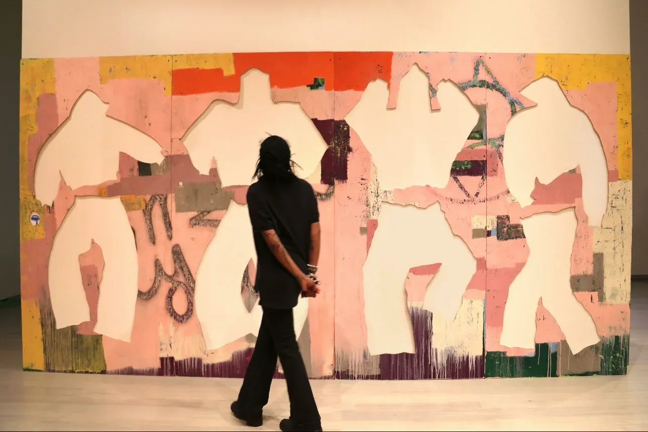Large pink panel with cut-out clothing silhouettes; viewer walking past; painting as object, erasure and identity.