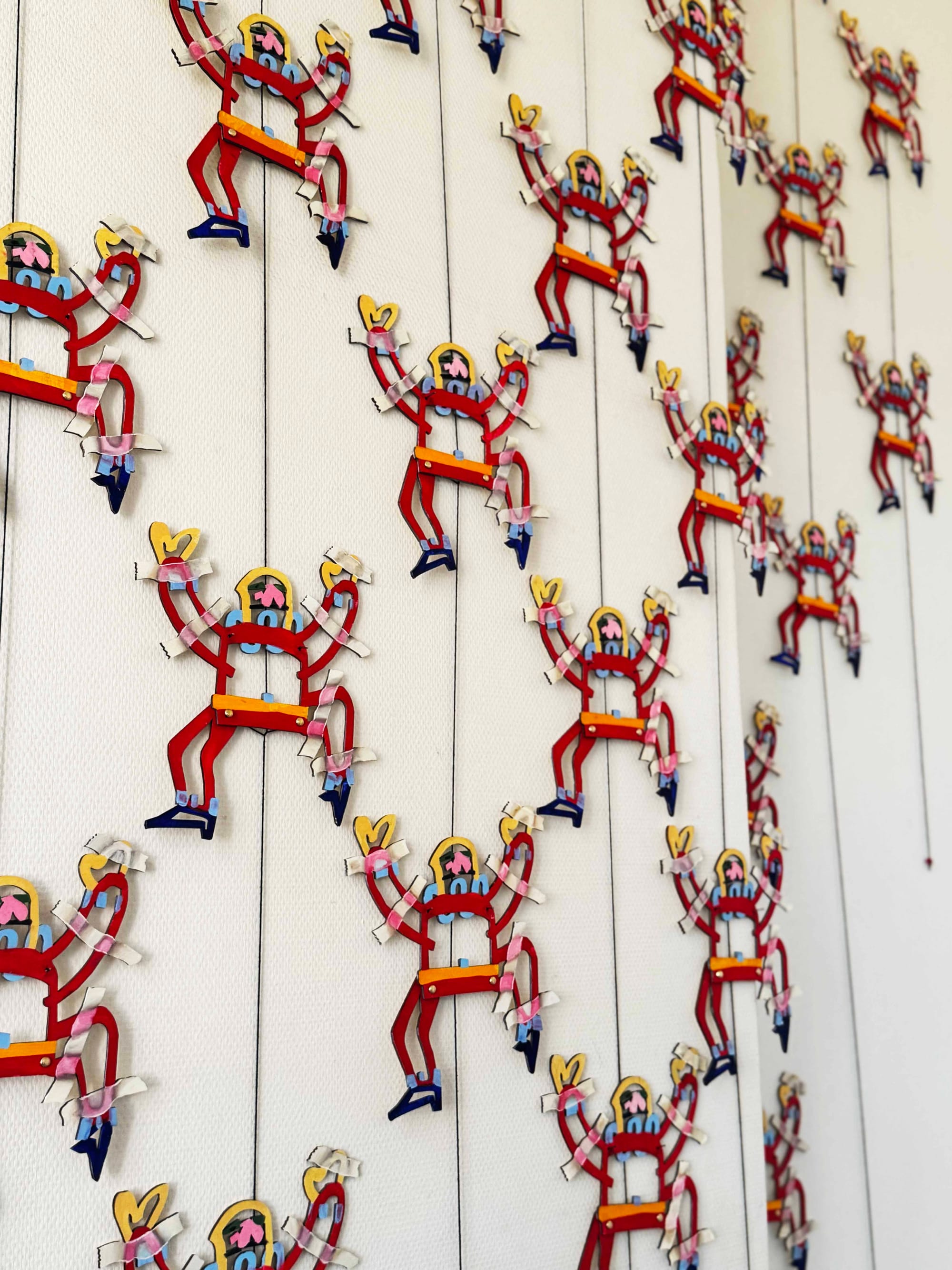 Parallel Vienna 2025: Installation by Sebastian Kelemer with rows of colorful cut-out figures attached to strings, exhibited in the Artist Statements section at the Otto Wagner Areal, Vienna.