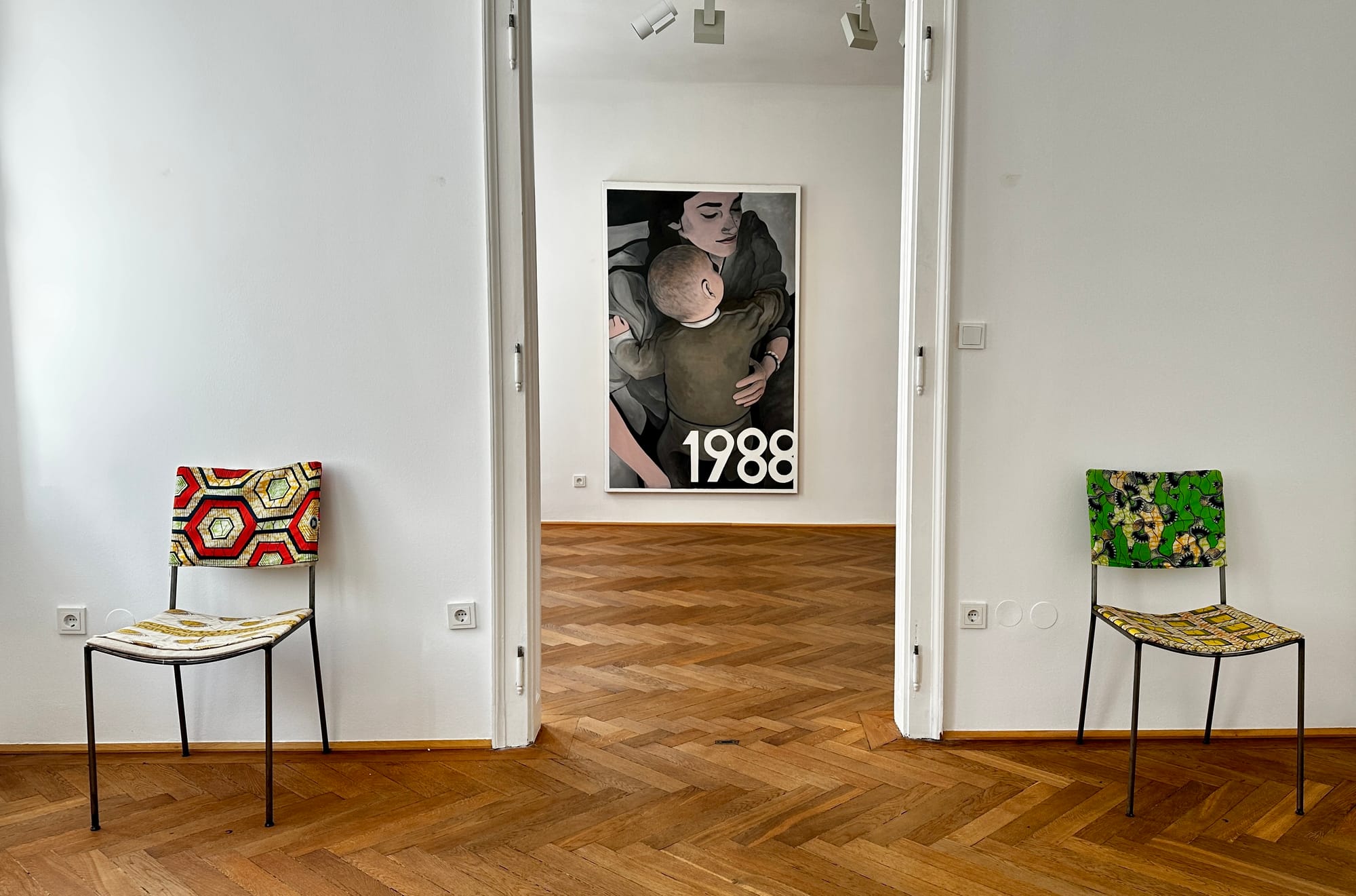View through a doorway toward the mother-and-child painting from Tin Trohar’s “1996” at Klubhaus, Vienna. 2 chairs infront from artist Franz West.