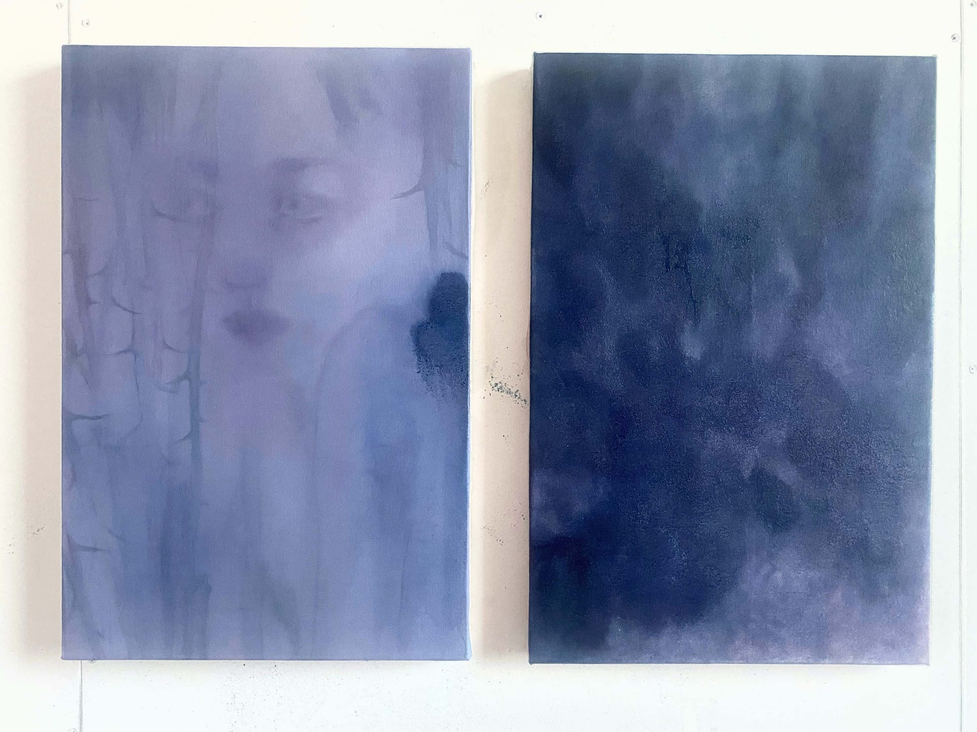 2 cyan blue paintings by the artist one of a woman and one of a sky like depiction hanging on the wall
