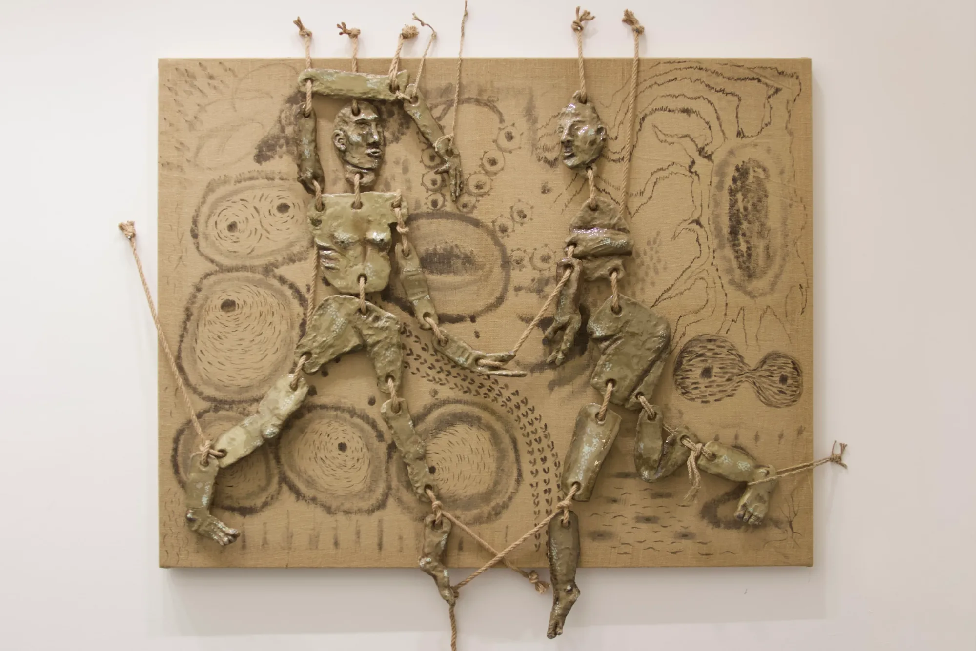 Seung-yeon Jung, The Moment of Janggu, 2025, mixed-media wall work showing two connected human forms made of resin and rope on jute fabric.
