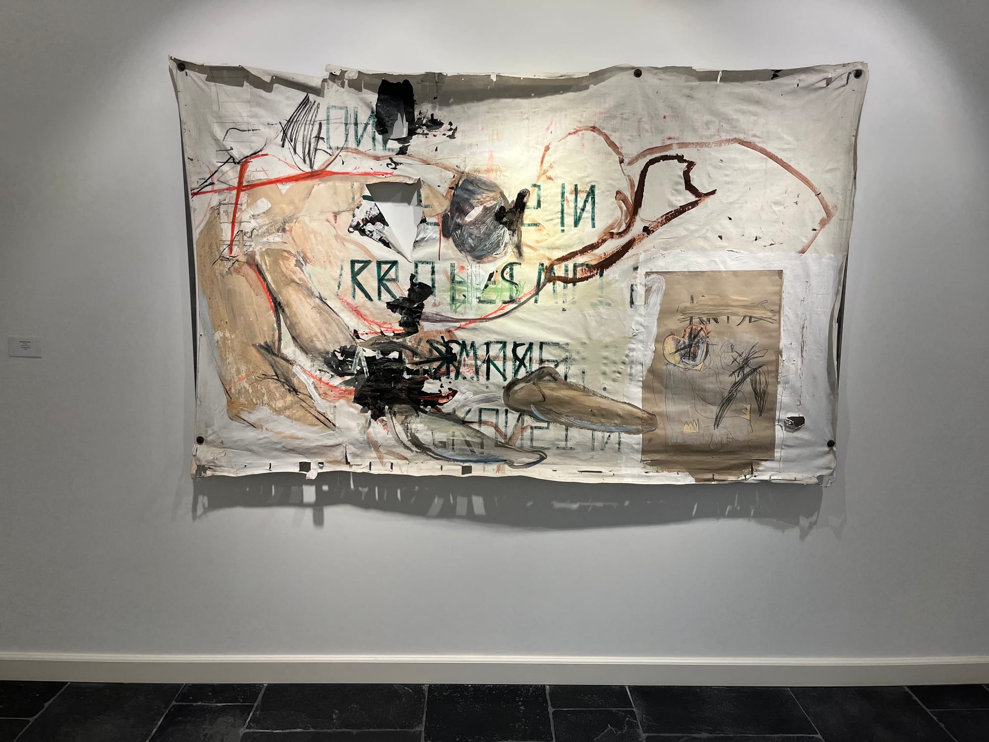 Ruth Devriendt’s mixed media work Krisis from 2025, shown as an installation view at Black Swan Gallery, displayed on a light wall above a dark stone floor. Image courtesy of the artist.