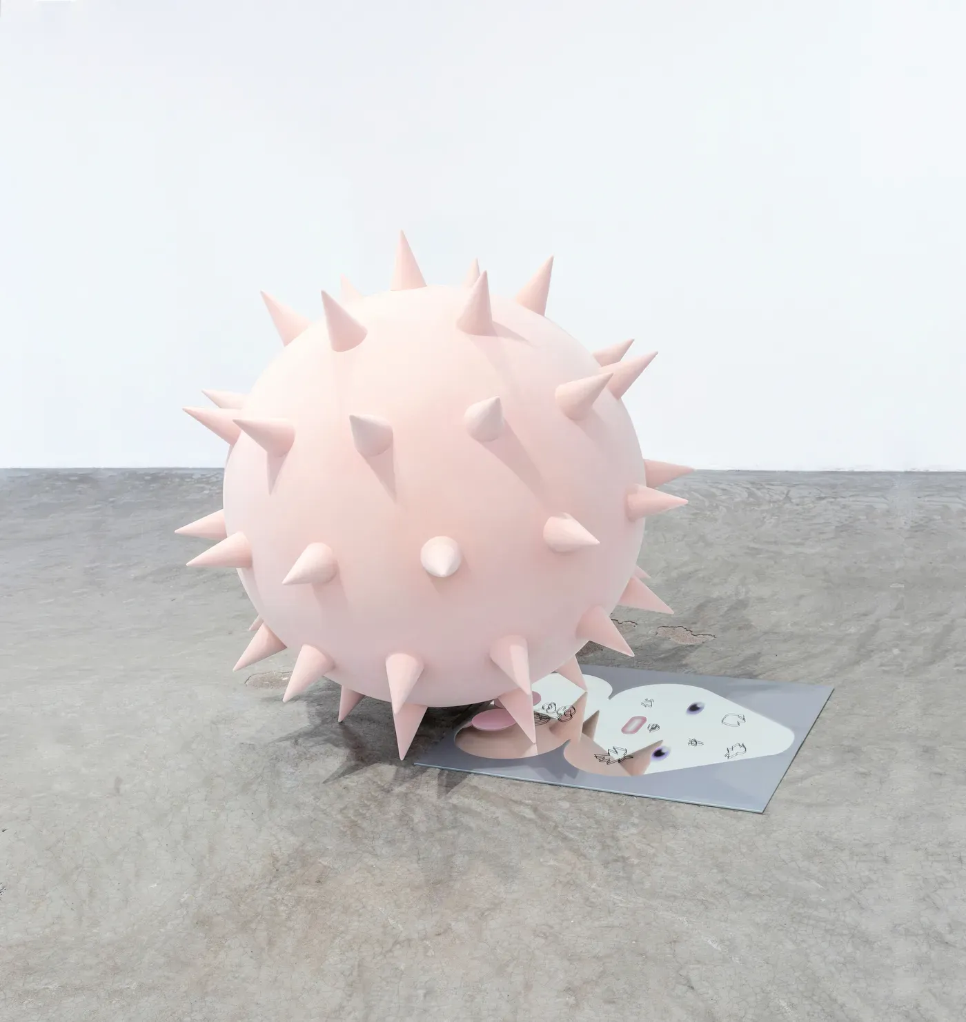 Sculpture NETWORK MIRROR by Grip Face. A pale pink spiked sphere made of carbon fiber and velvet rests on a mirrored surface printed with a stylized face. The work, from the duo show FIND AN OFFLINE SHELTER with @mijuleee, explores identity and digital saturation.