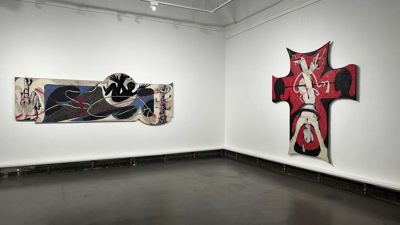 Installation view of Egor Lovki’s exhibition “I Smiled but Misunderstood” at Bildraum 01, Vienna, showing two large-scale mosaic works in black, red, blue, and white tones presented in a minimalist gallery space.