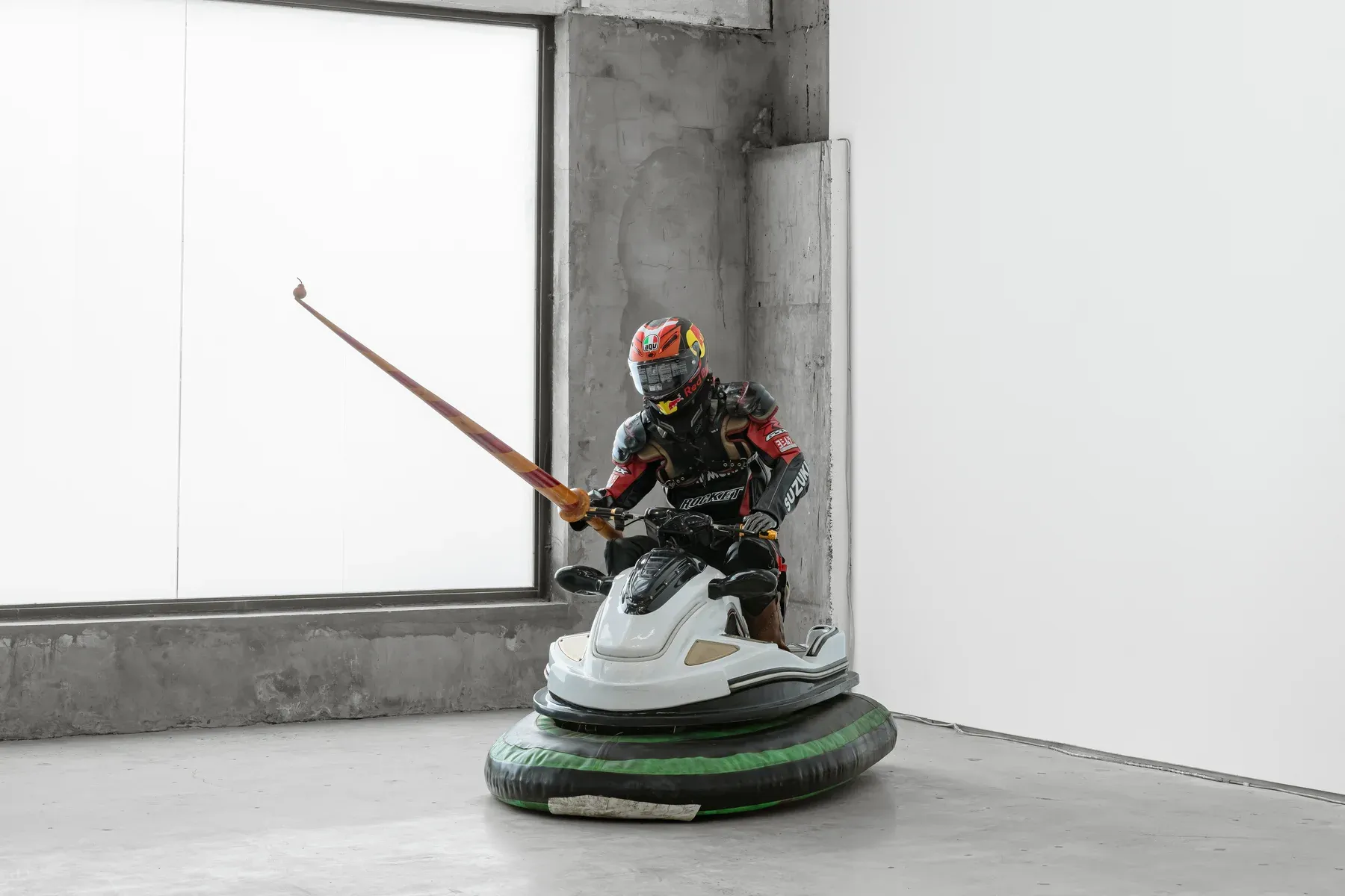 Gene Gallery , Shanghai, artist Xiaozhou Liao, Armored figure riding a modified bumper car while holding a long lance, positioned in a corner of a bright concrete gallery.