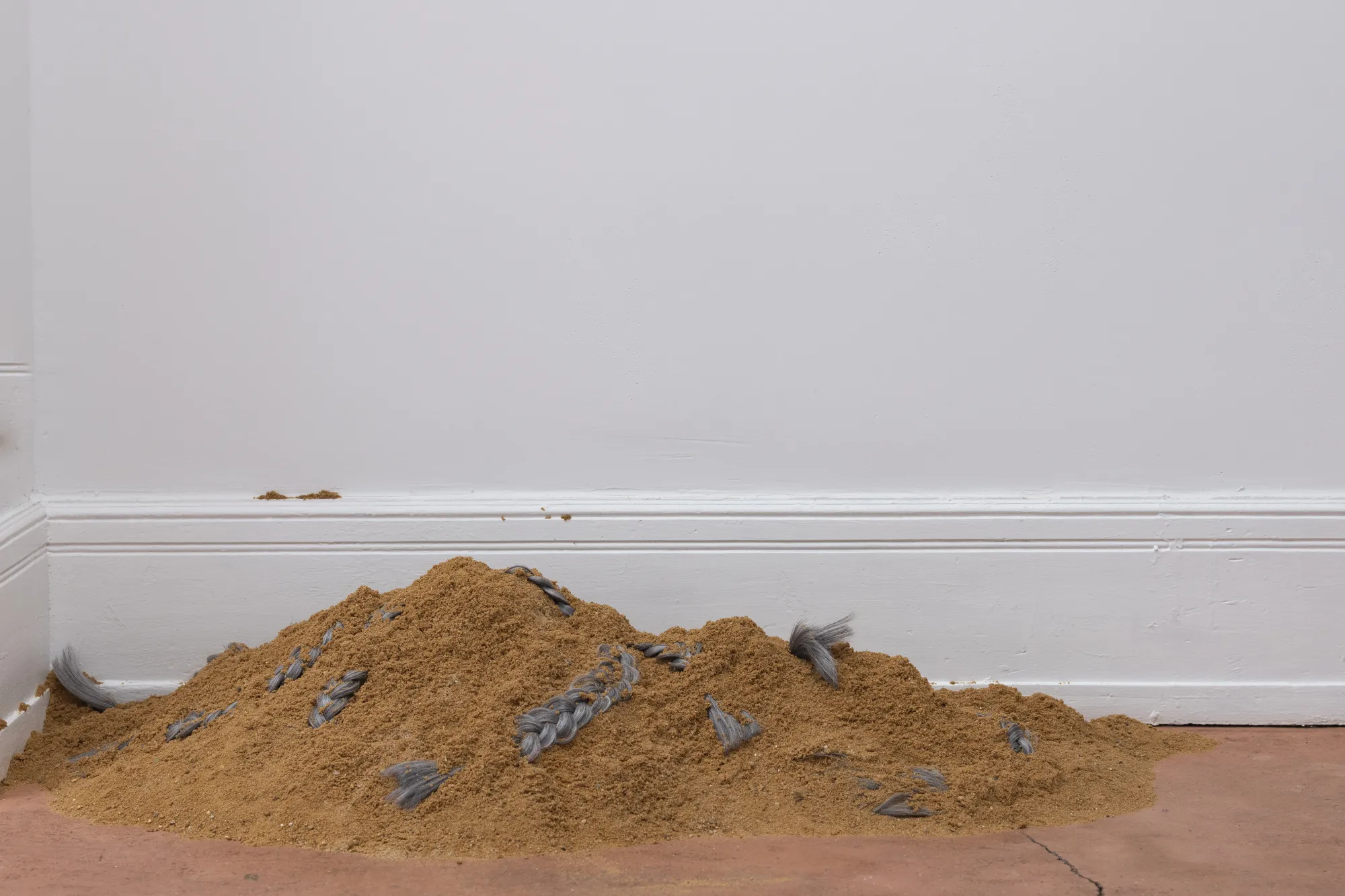Installation view of After Unrast by Nadine Karl at Kunsthalle Düsseldorf, showing a glass display with sculptural elements and a large black-and-white photographic work mounted on the wall.