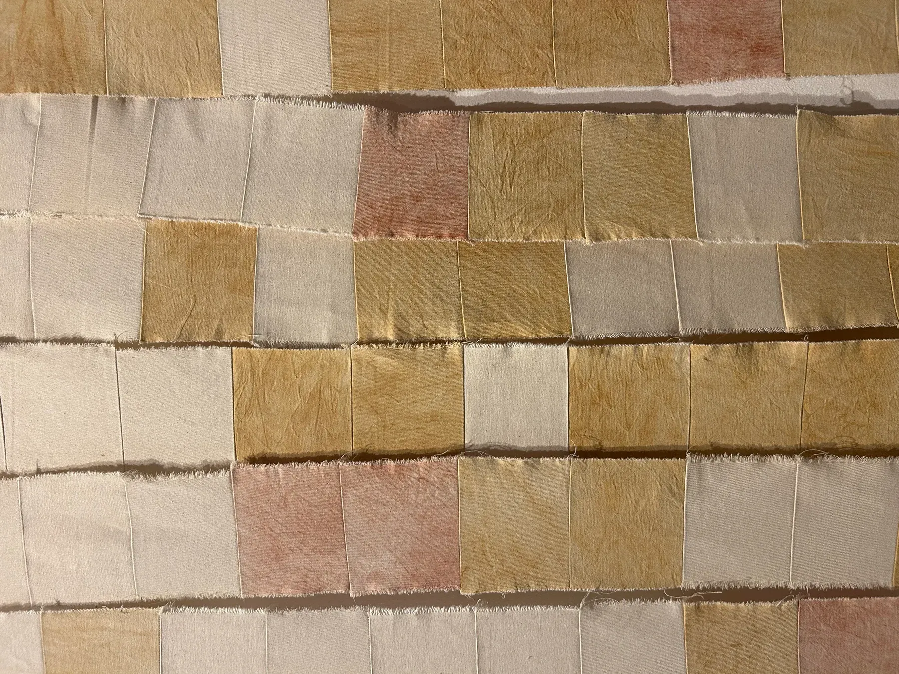 Detail of Landscape I, work composed of stitched canvas strips dyed with natural fabric pigments, creating a rhythmic surface of earthy, uneven color blocks.