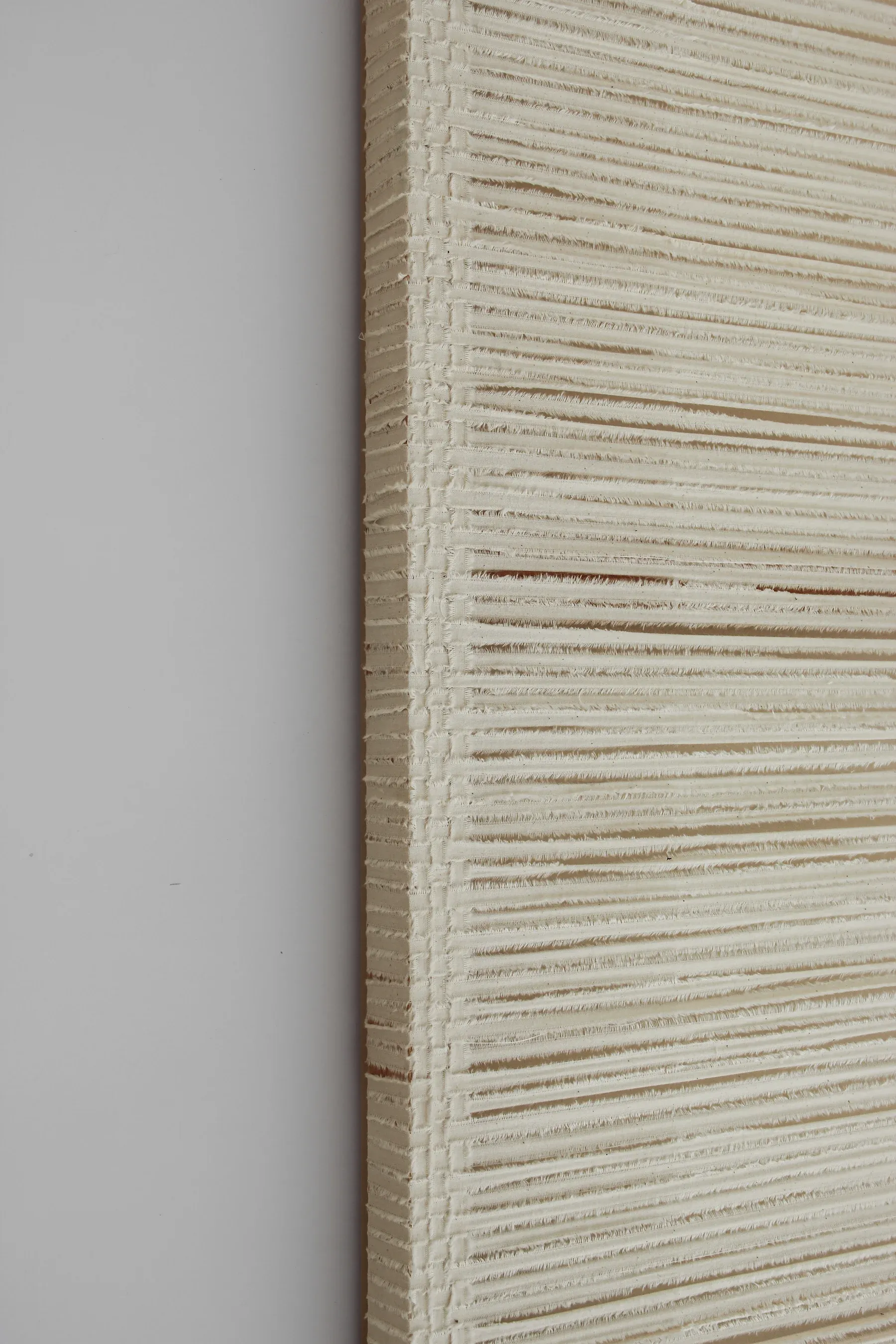 Detail of a square textile work composed of tightly layered horizontal canvas lines, creating a dense, rhythmic surface with subtle tonal variation across the field.