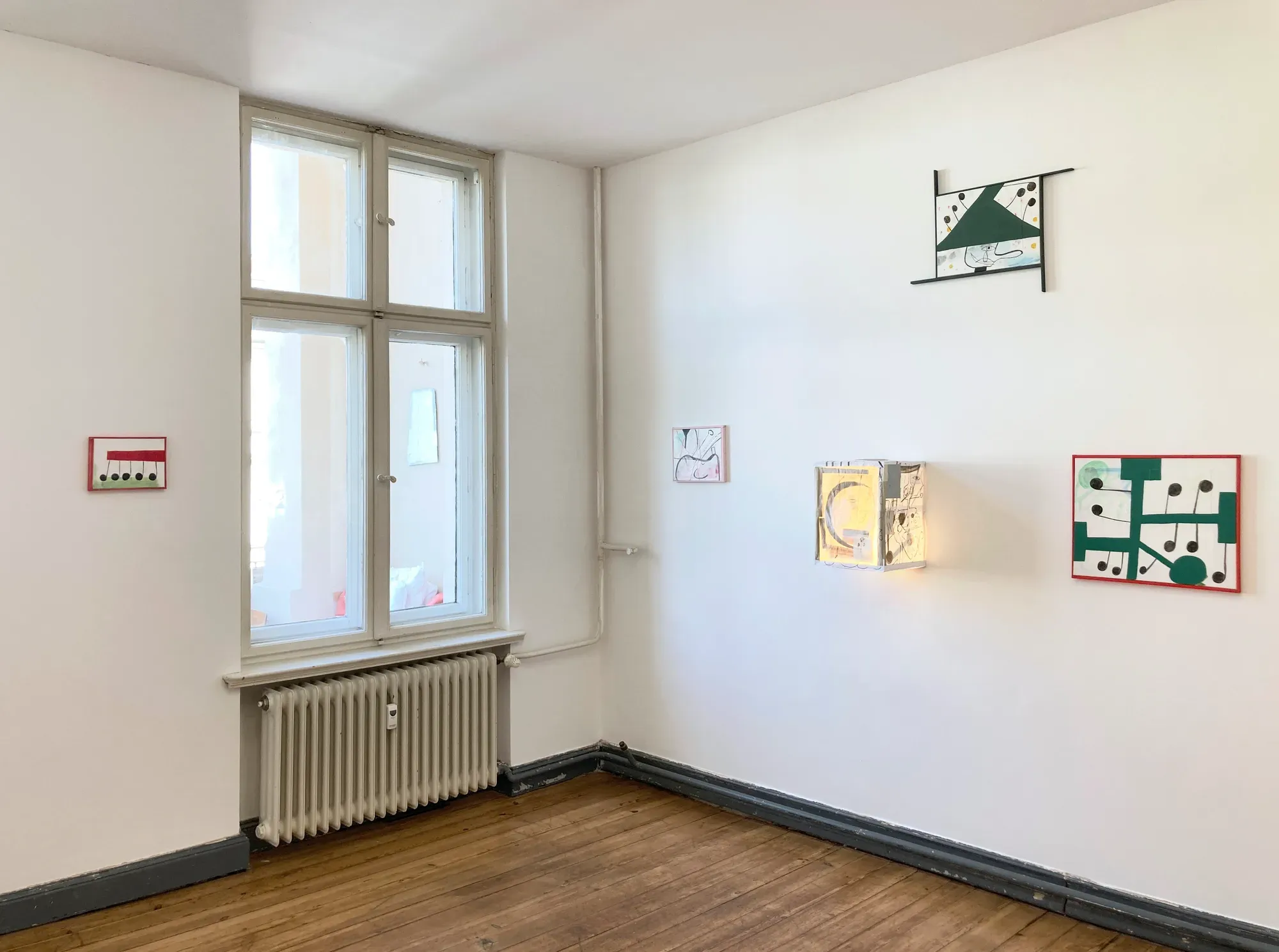Tom Król, “Studio presentation,” 2023, installation view showing small framed works and a light box displayed on white walls in a minimal studio space.