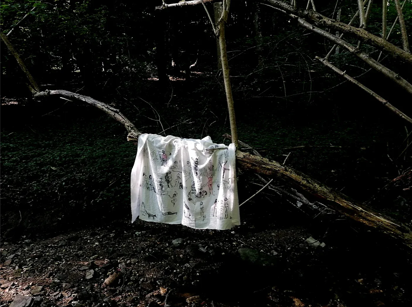 Julia zöhrer , artist in focus, textile presented outdoor in the woods with figurative drawing