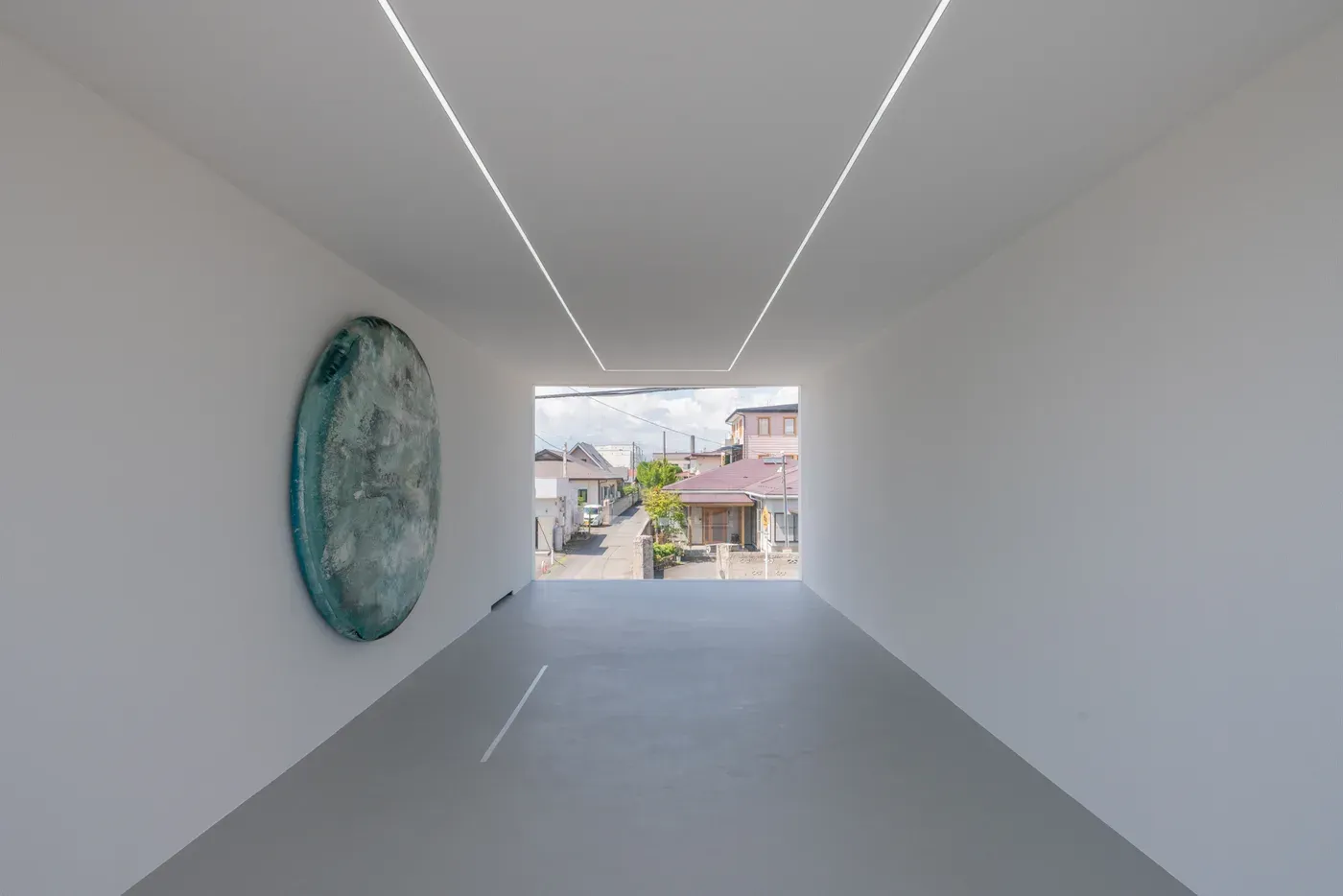 Exterior perspective of 目 [mé]’s architectural intervention space (2020) at Towada Art Center, showing an exposed staircase leading to a glass-fronted interior space inserted into the building façade.