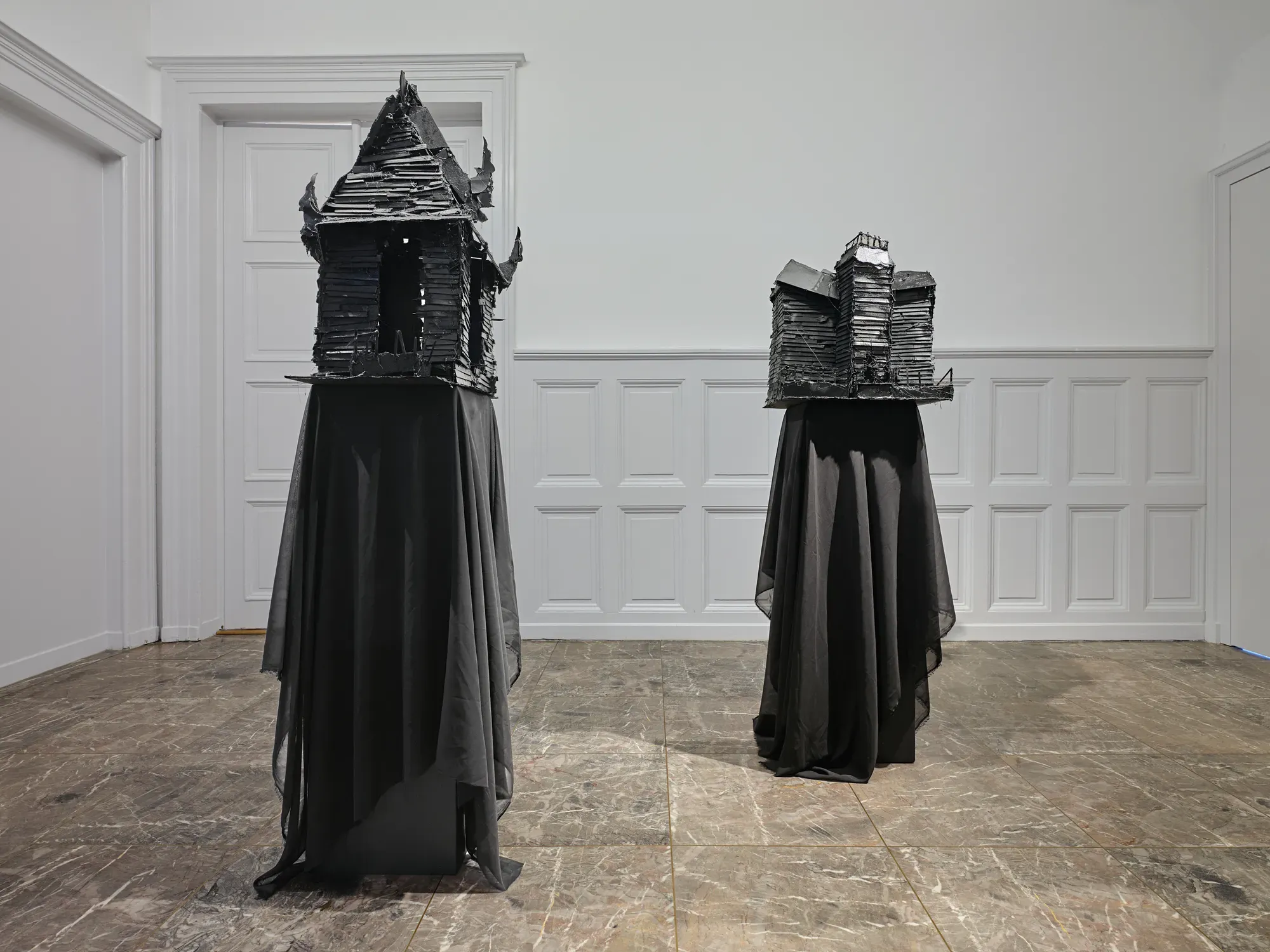 Gregory Tara Hari placed on pedestal stands draped with black fabric in a gallery room at Villa Bernasconi, part of the exhibition “Stitches: A Haunted House and Other Ghost Stories”, 2026.