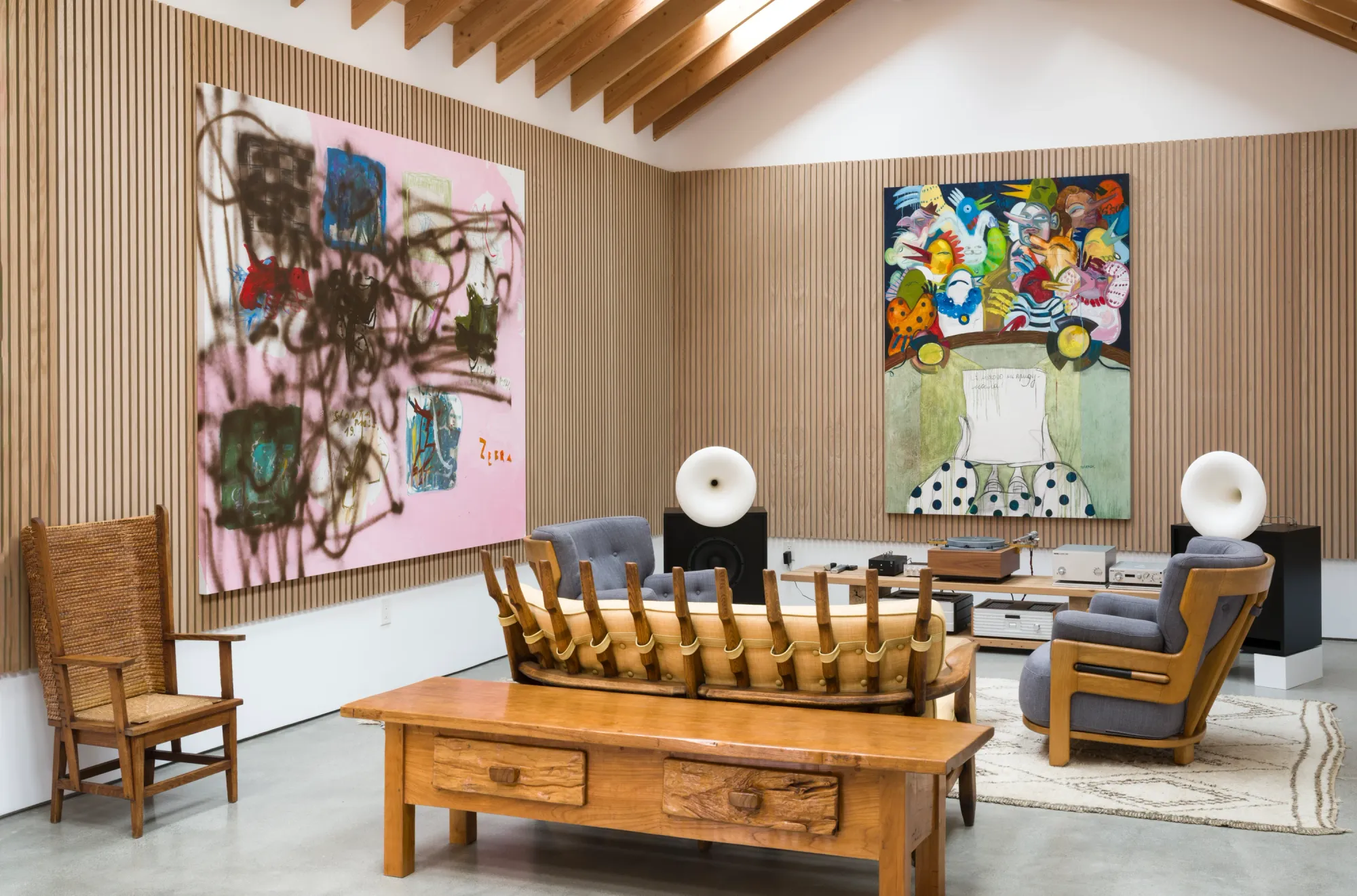 Installation view of Dinner Table at Simchowitz Hilltop, Los Angeles, featuring large paintings by Andrey Samarin and Lera Derkach in a wood-paneled gallery lounge with vintage seating and hi-fi speakers.