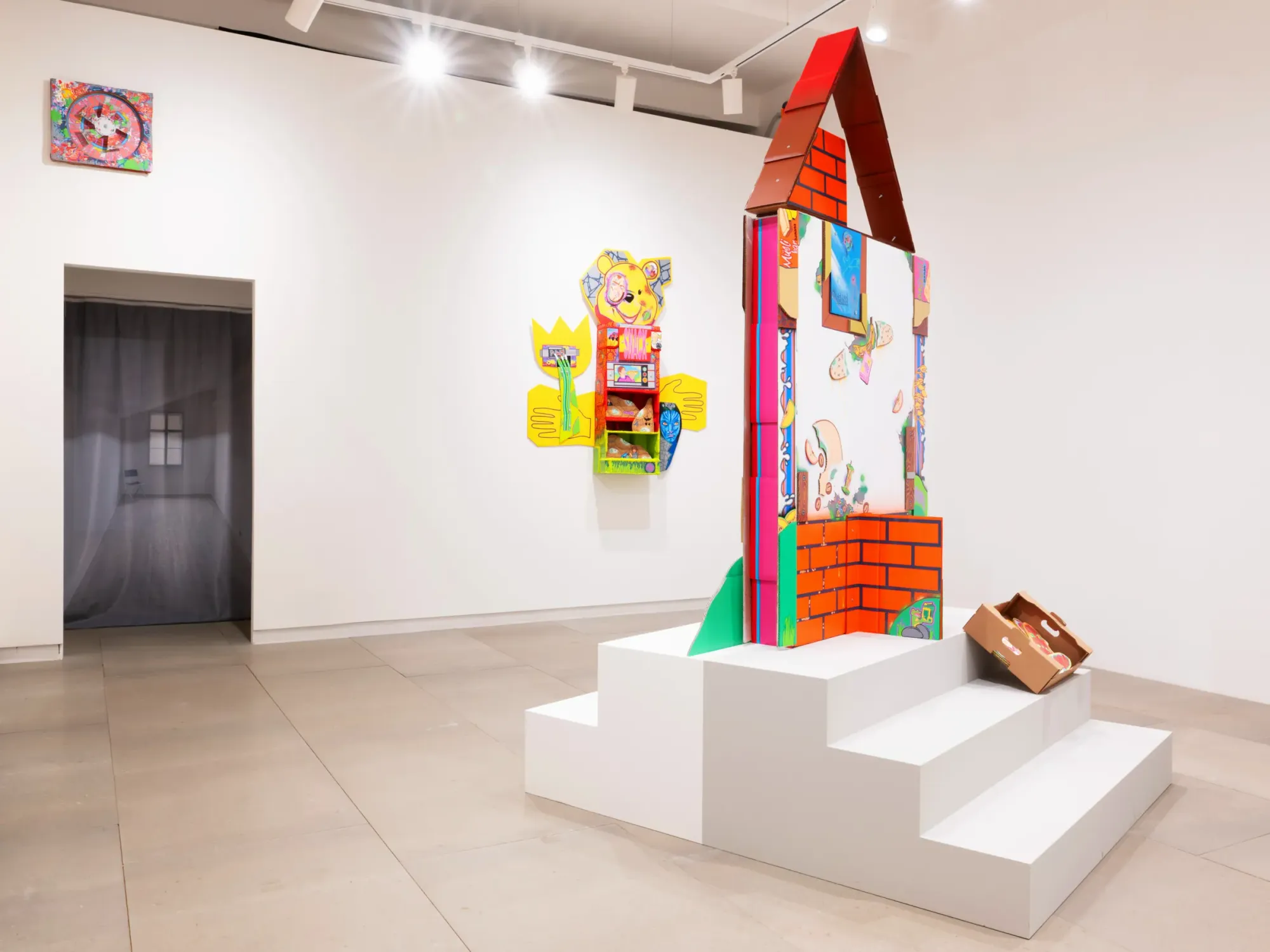 Colorful cardboard temple installation with hand-drawn graphics and stepped plinth, exhibition view Daniela Ponomarevová Temple of Health