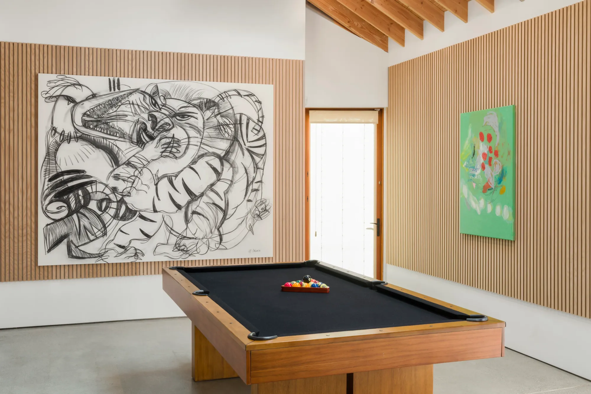 Installation view of Dinner Table at Simchowitz Hilltop, Los Angeles, with multiple paintings by Andrey Samarin and Lera Derkach displayed around a pool table.
