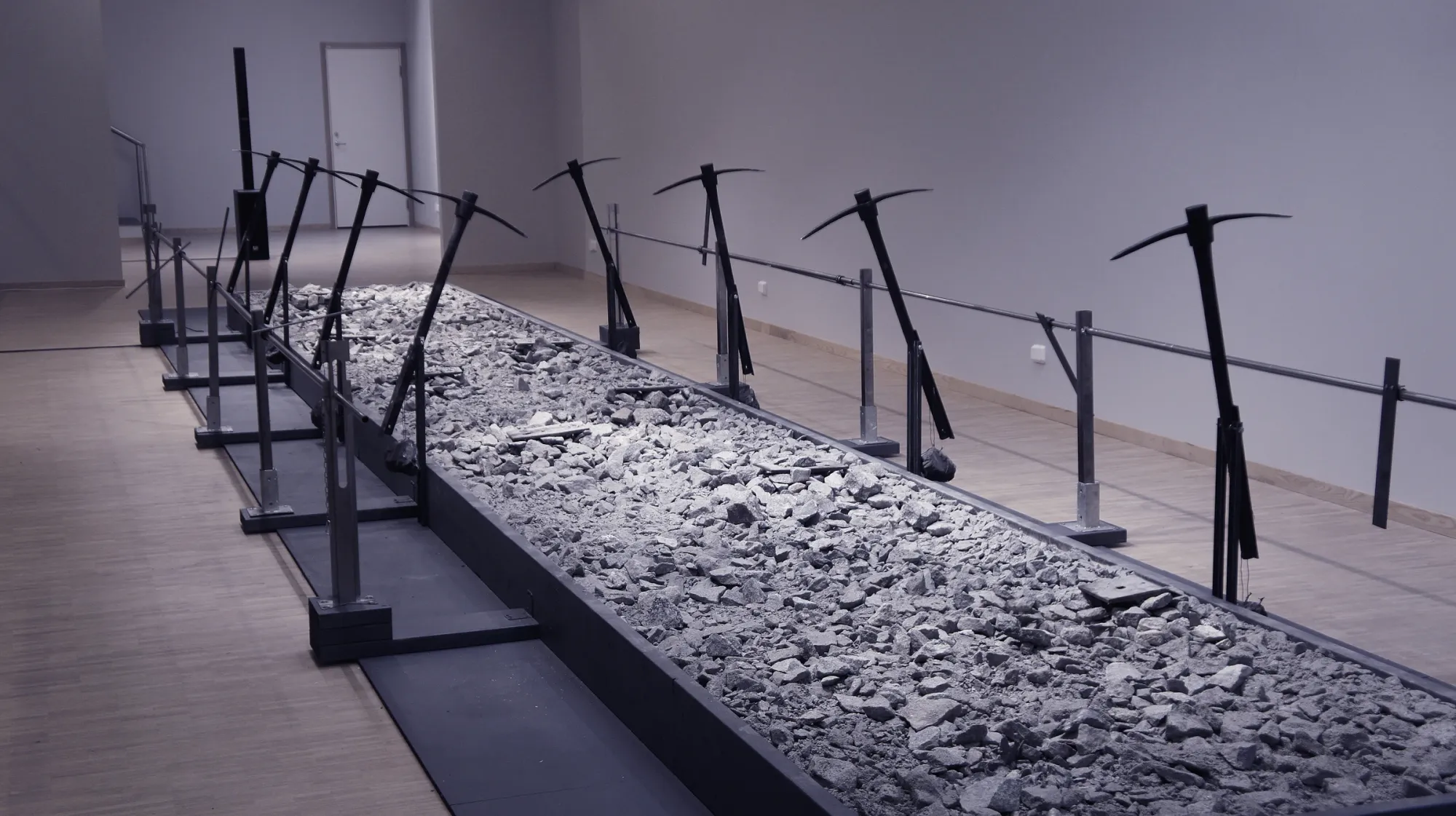 Andreas R Andersson: Long installation with rocks and suspended pickaxe forms, Road of Bones, Piteå Konsthall 2023, Photo by Andreas R Andersson