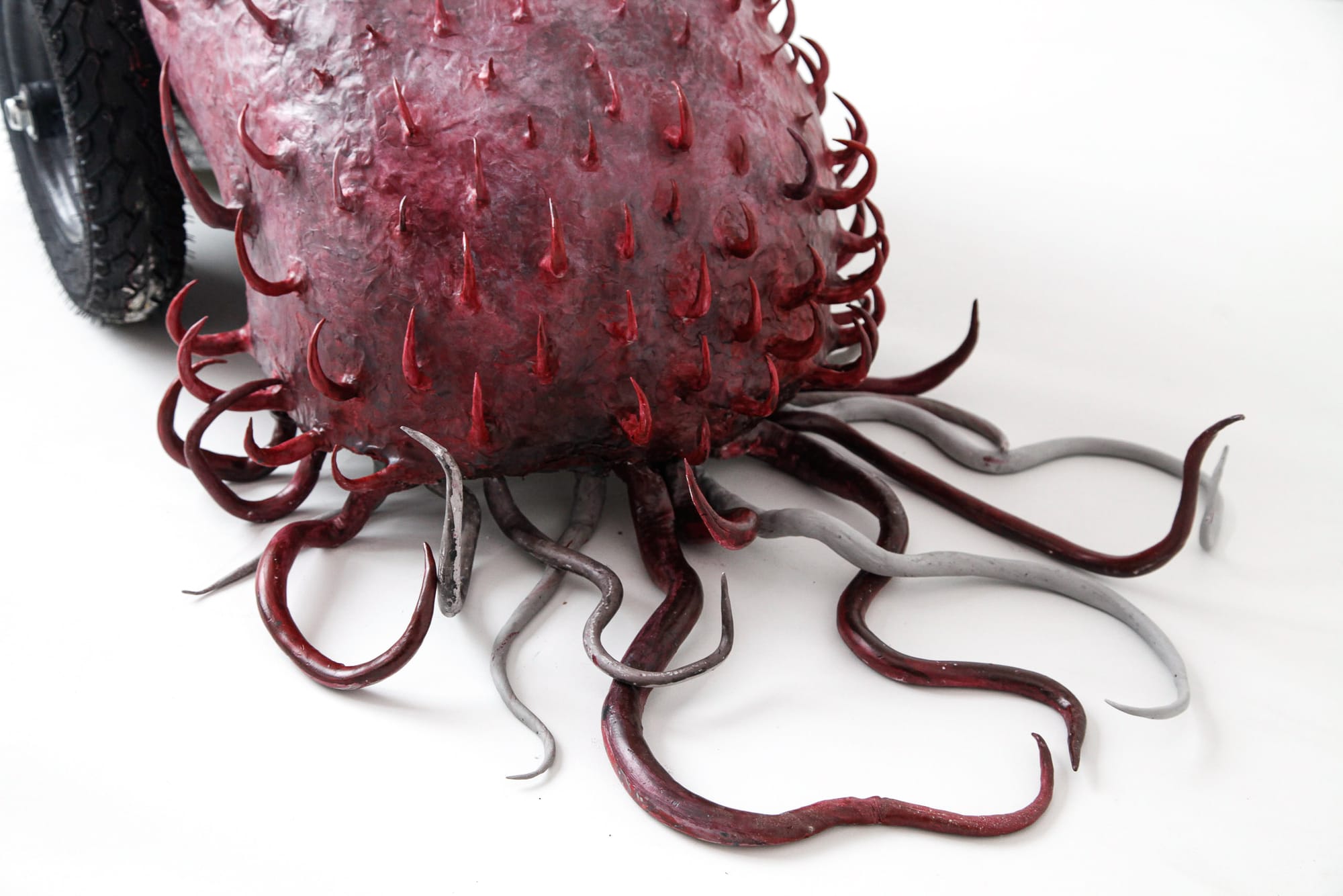 Shirley Fu Blood on Track 1 2024 hybrid sculpture with red spiked surface and organic tentacle forms emerging from tyre based structure