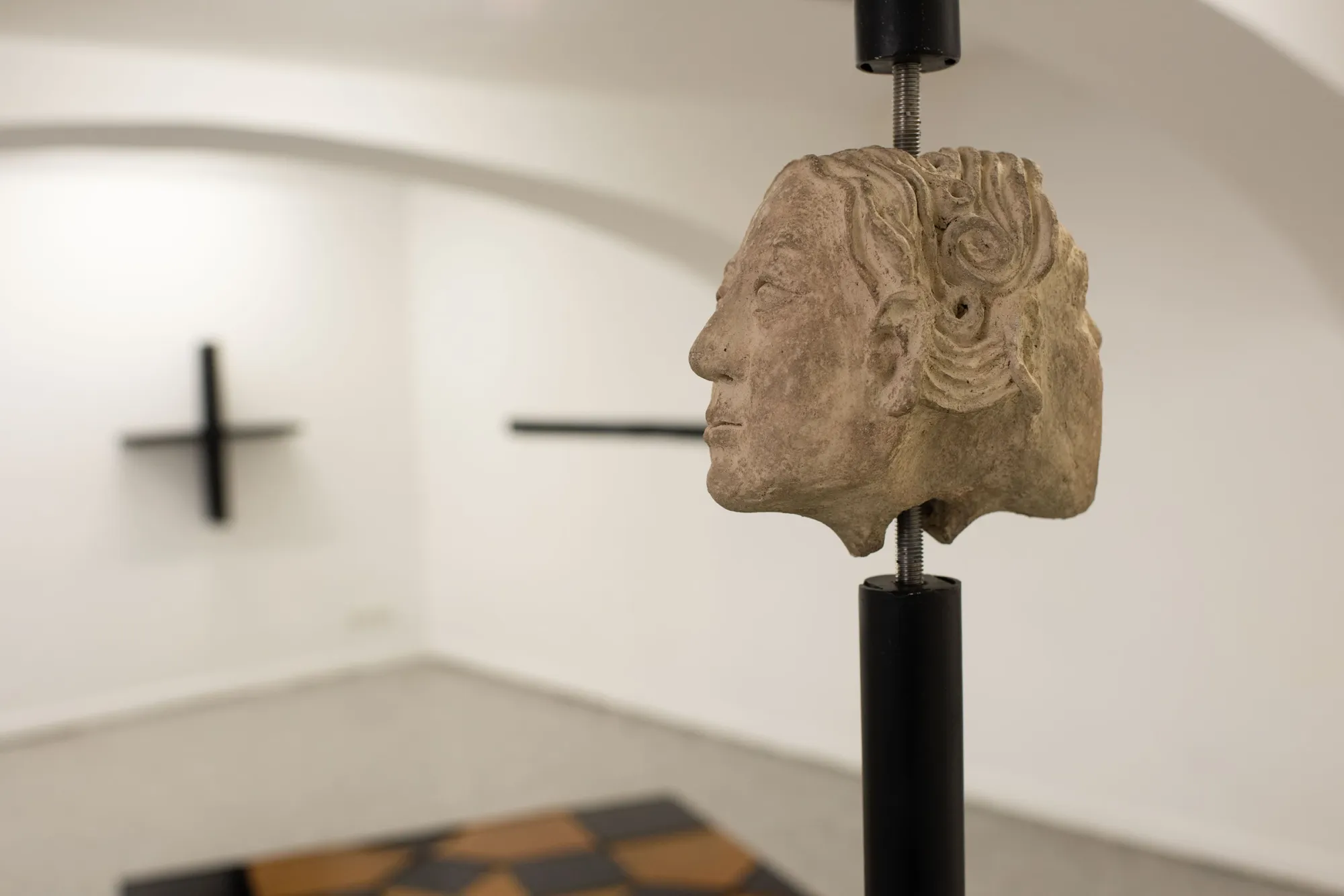 Céline Struger MOTH AS IN MOTHER II sculpture with stoneware head mounted on vertical steel structure in exhibition space