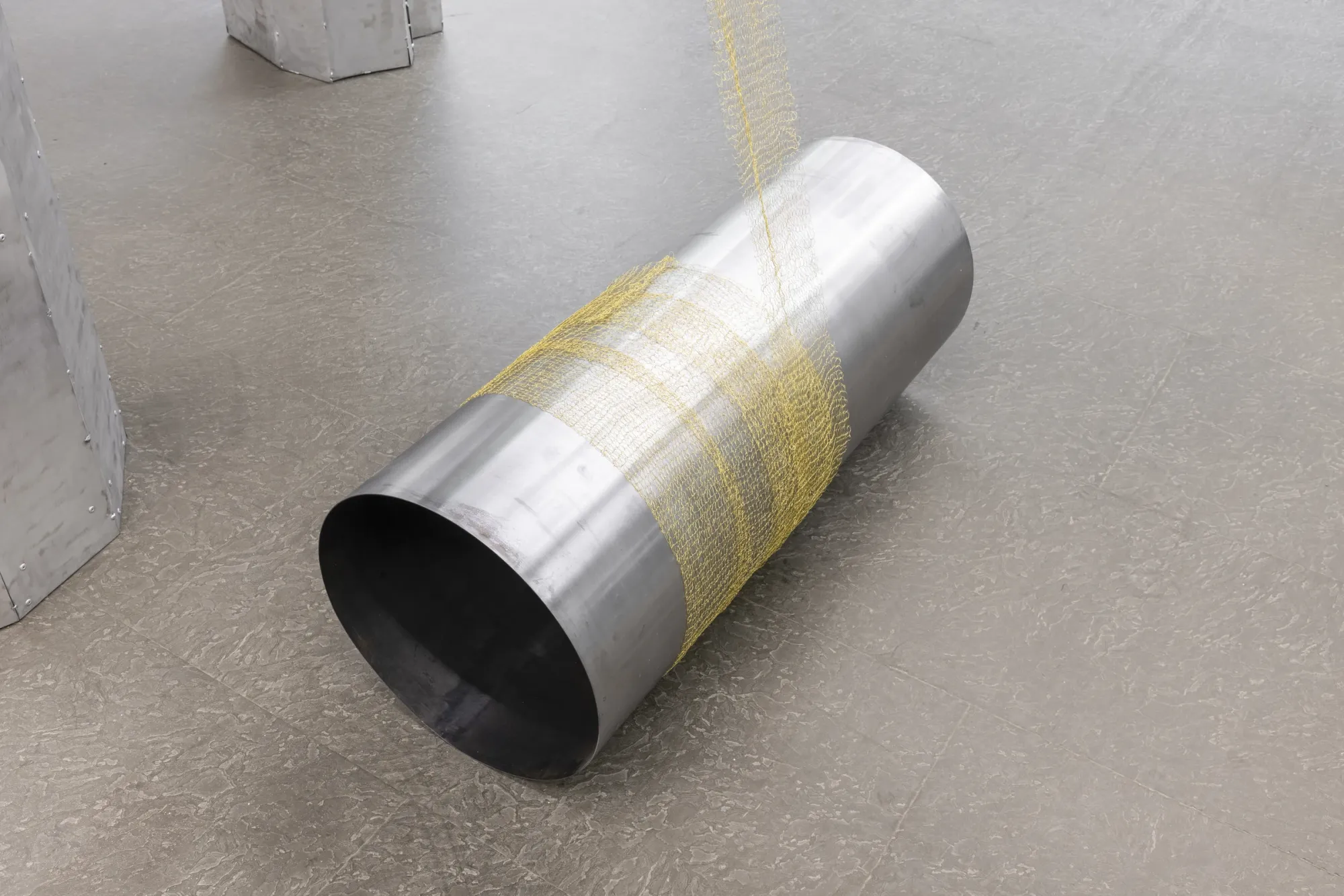 Maija Fox Hard Shoulders detail showing cylindrical steel form wrapped with woven metal wire resting on gallery floor