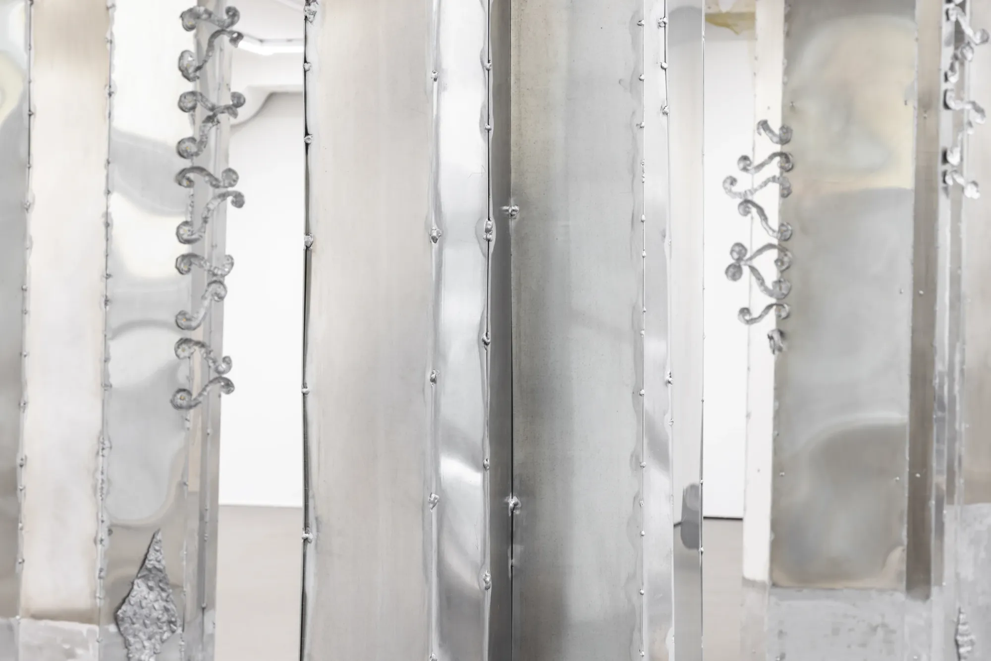 Maija Fox Hard Shoulders detail showing metal column surfaces with cast aluminium textures and welded elements inside installation at Sinne Helsinki