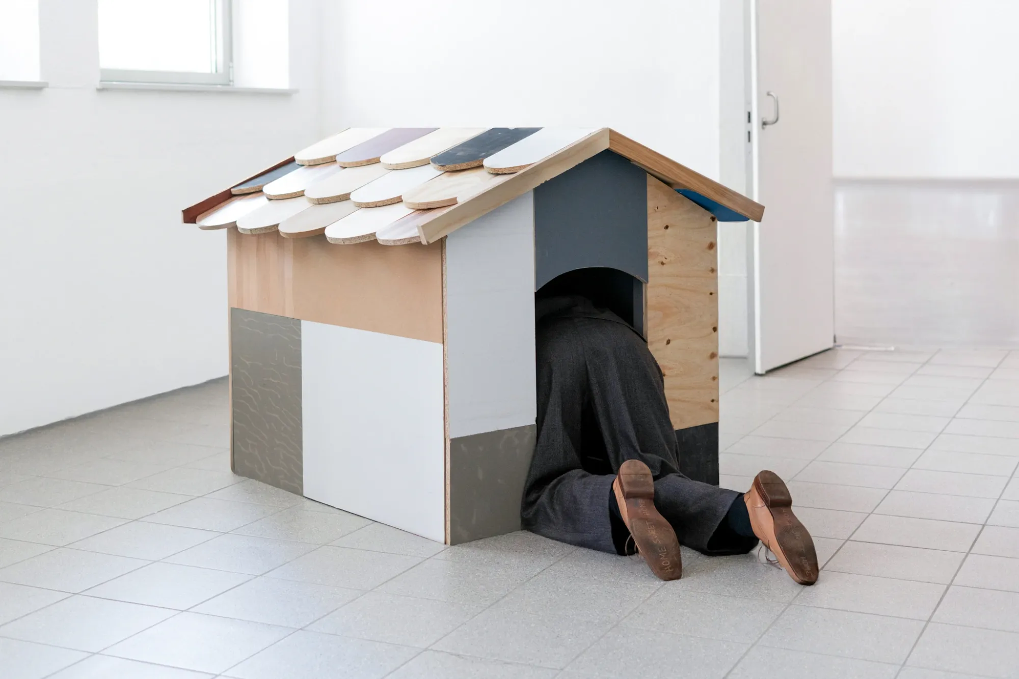 Stasia Grishina Man on all fours 2025 installation view HfG Offenbach wooden doghouse sculpture human figure inside Artist in Focus by Catapult