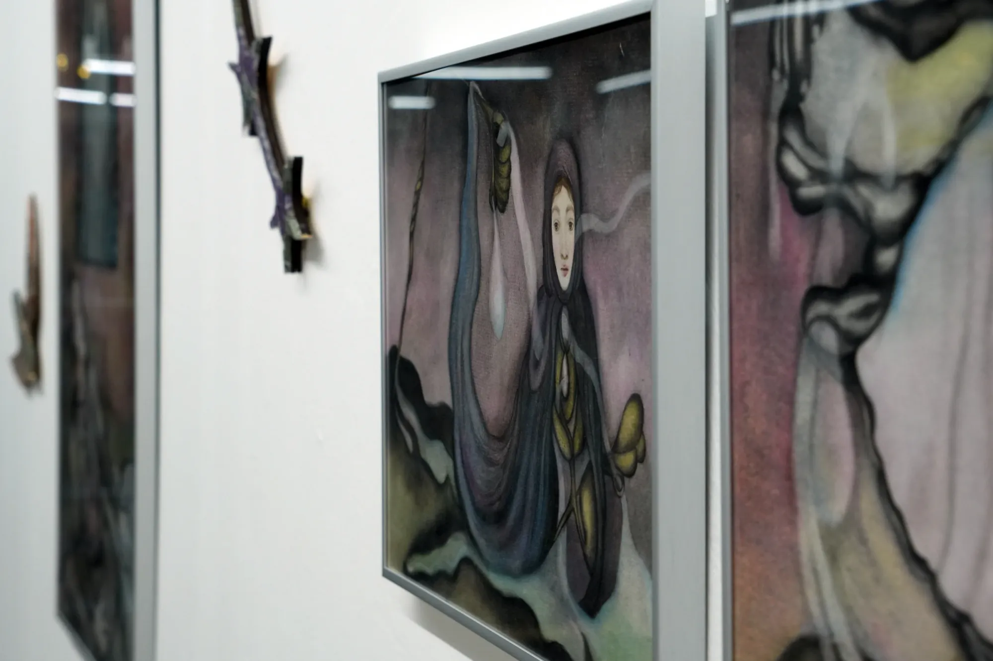 Catalogue of Sensory Data, installation view — centre: Nata Varazi, Untitled, 2025, oil on canvas showing cloaked female figure with large eyes emerging from dark swirling forms and olive plant elements; left wall: Gvantsa Jishkariani, felt star and bird forms; The Why Not Gallery at Fabrika Project Space, Tbilisi.