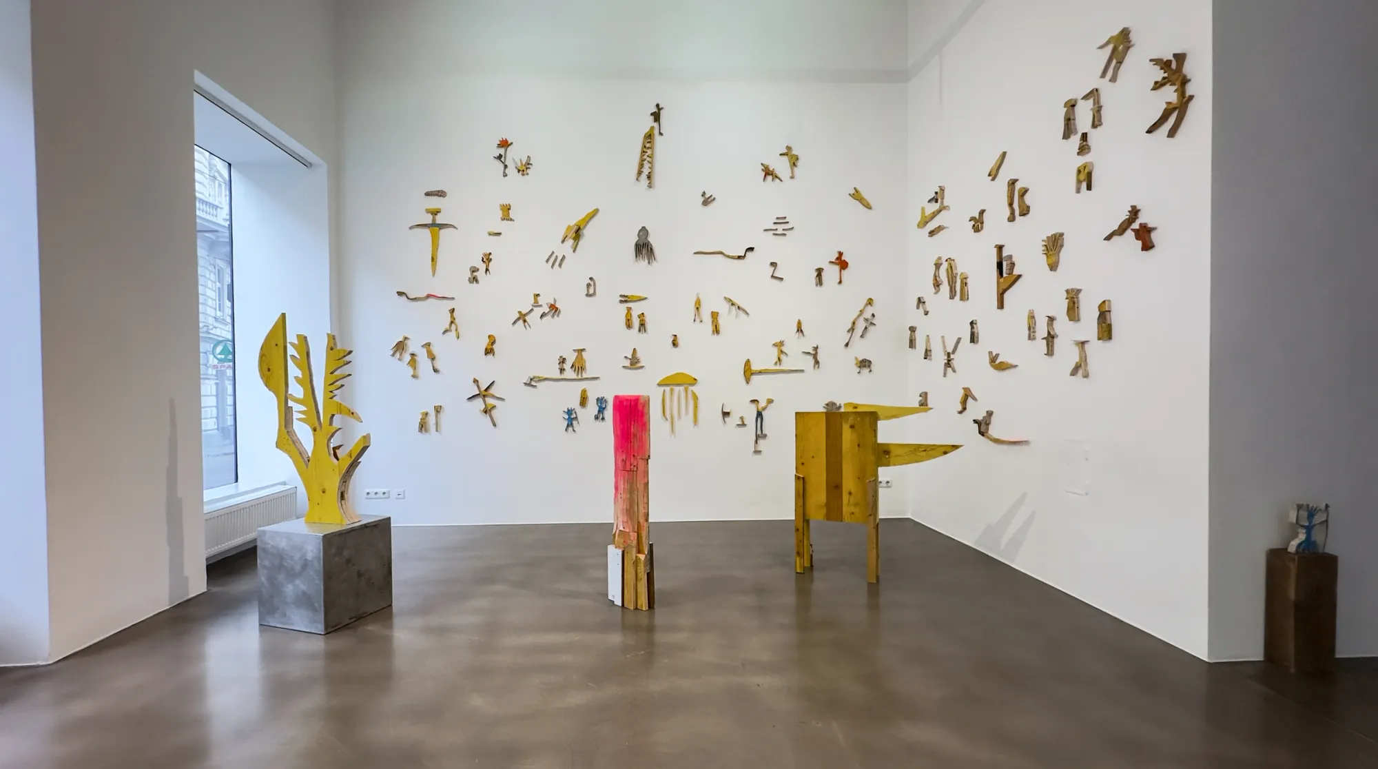 Ernst Koslitsch, installation view with wall constellation of wooden fragments and floor sculptures, Cosmic Trigger – Respawn, Bildraum 07, Vienna, 2026
