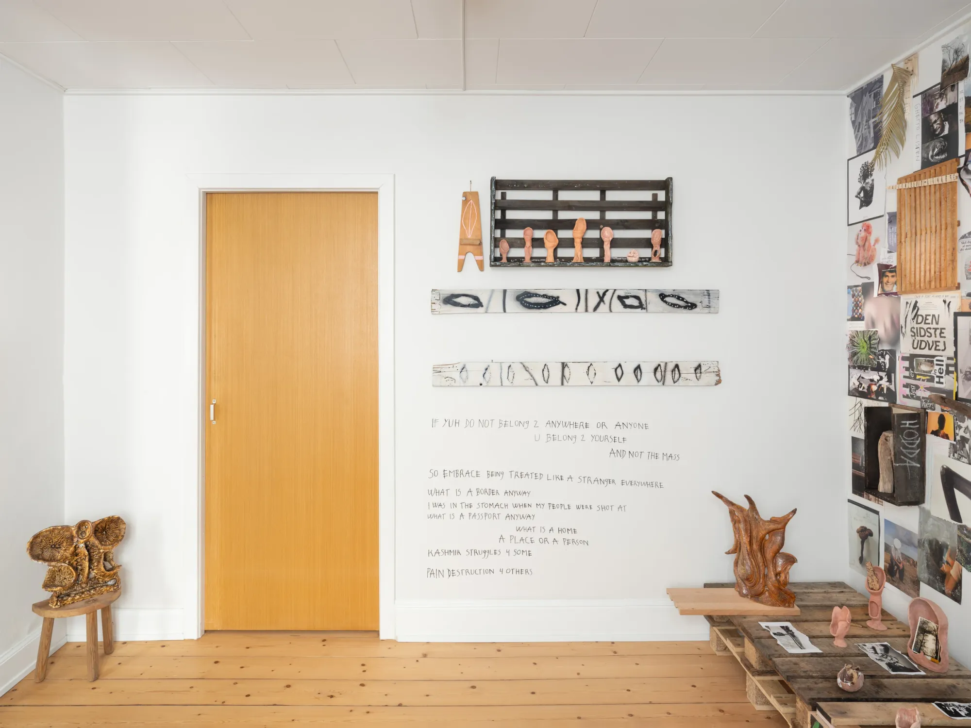 Gallery Fusion: Rune Lambrecht installation view with hand-written wall text, ceramic works on wooden rack and sculptures on palettes, Grihodda,