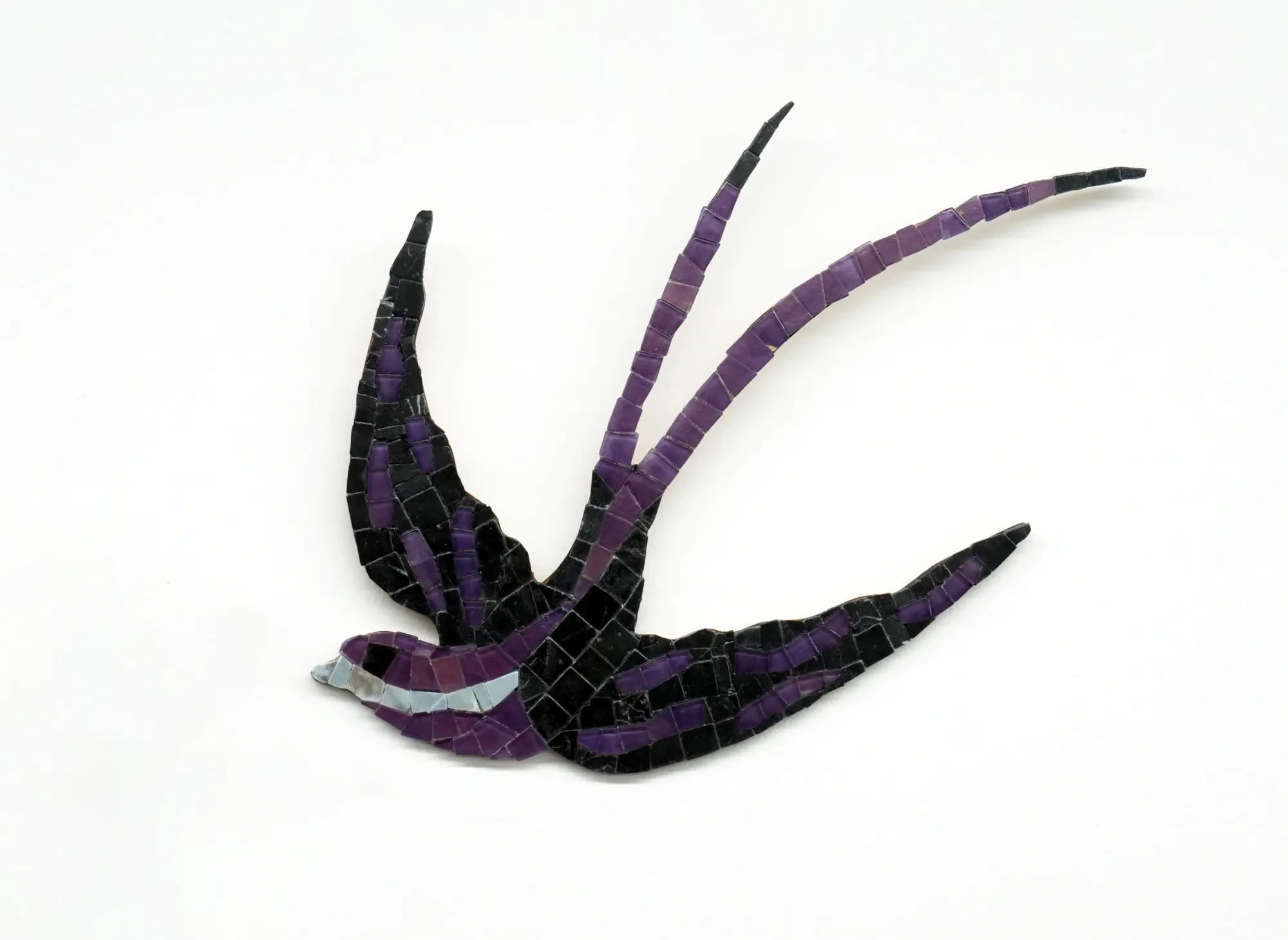Gvantsa Jishkariani, Curious Gangster, 2026 — wall-mounted mosaic swallow in mid-flight, composed of marble and beach glass tiles with a vivid green chest and elongated curved tail elements; The Why Not Gallery at Fabrika Project Space, Tbilis