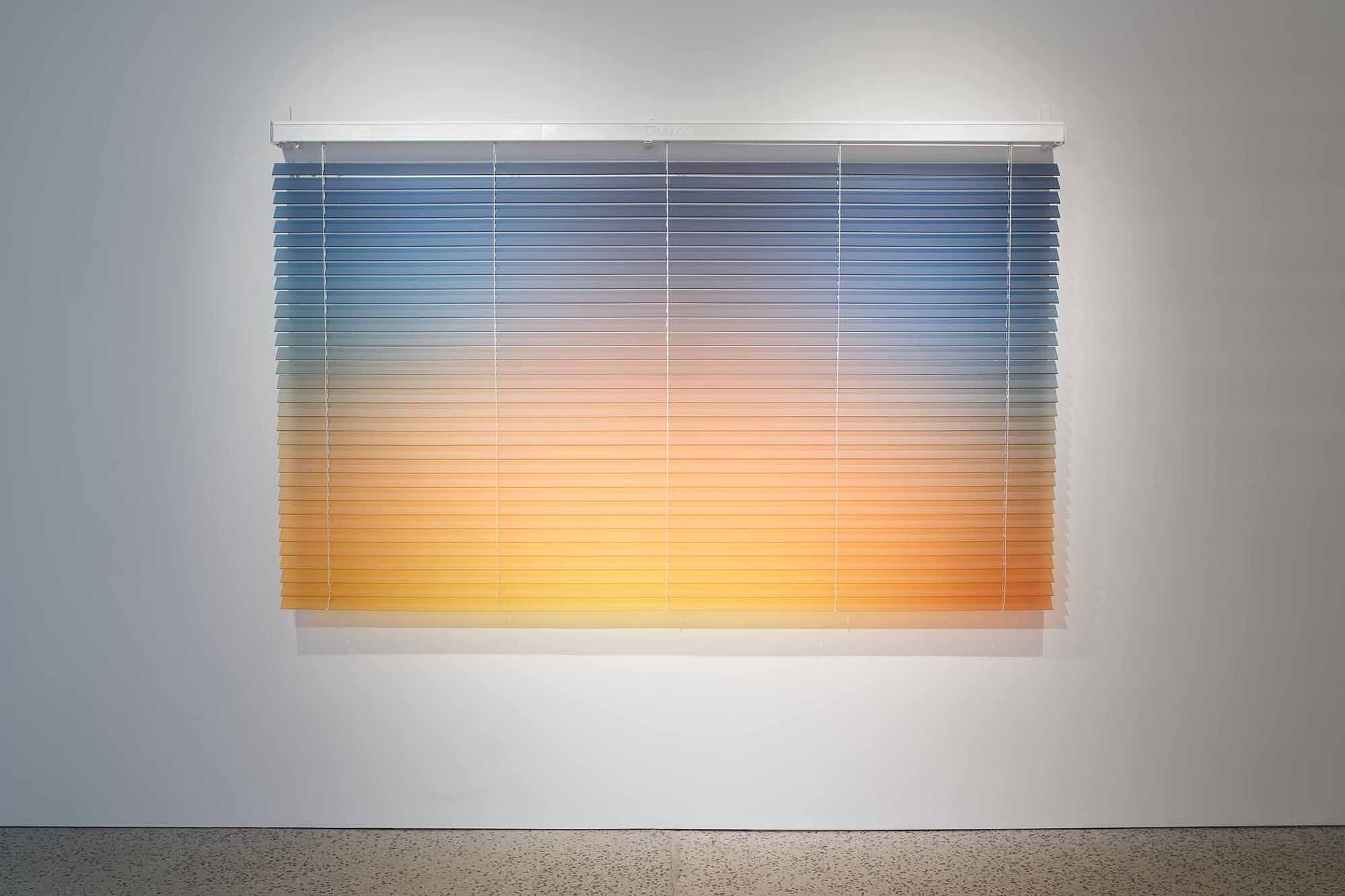 Thordis Erla Zoega, Forecast, detail: close-up of gradient venetian blind — cool blue-grey at top transitioning to warm amber and orange below — horizontal aluminium slats dividing the AI-generated sky into layered bands, BERG Contemporary, Reykjavík, 2025.
