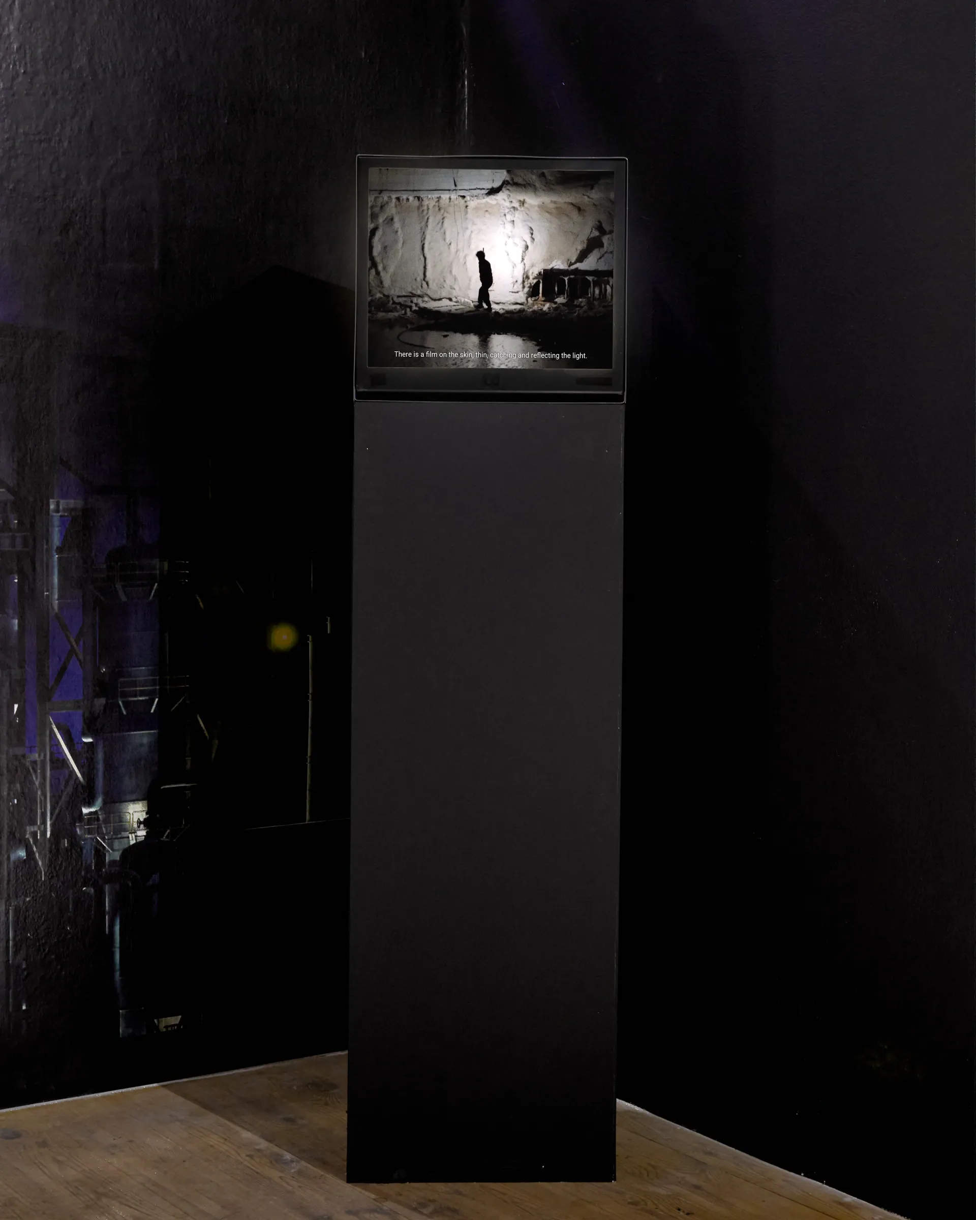 Anna Engelhardt, Towards Dissolution, Bleed Through, Galerie 35M2, Prague, 2026, video monitor on pedestal showing figure in industrial landscape