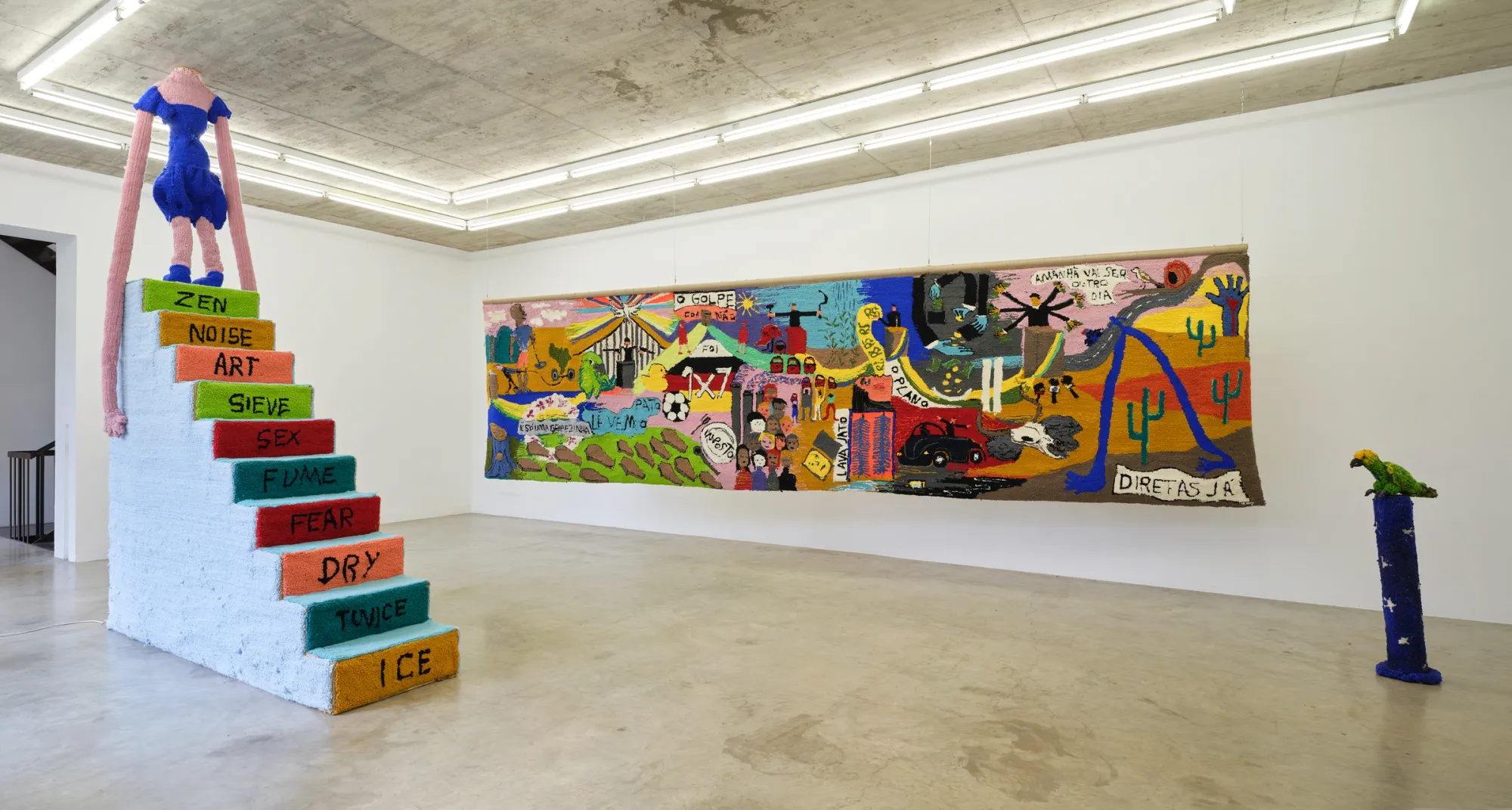 Elen Braga, Ich bin wie du, NAK Neuer Aachener Kunstverein, Aachen, 2026, wide view of first exhibition space with large textile work and staircase sculpture