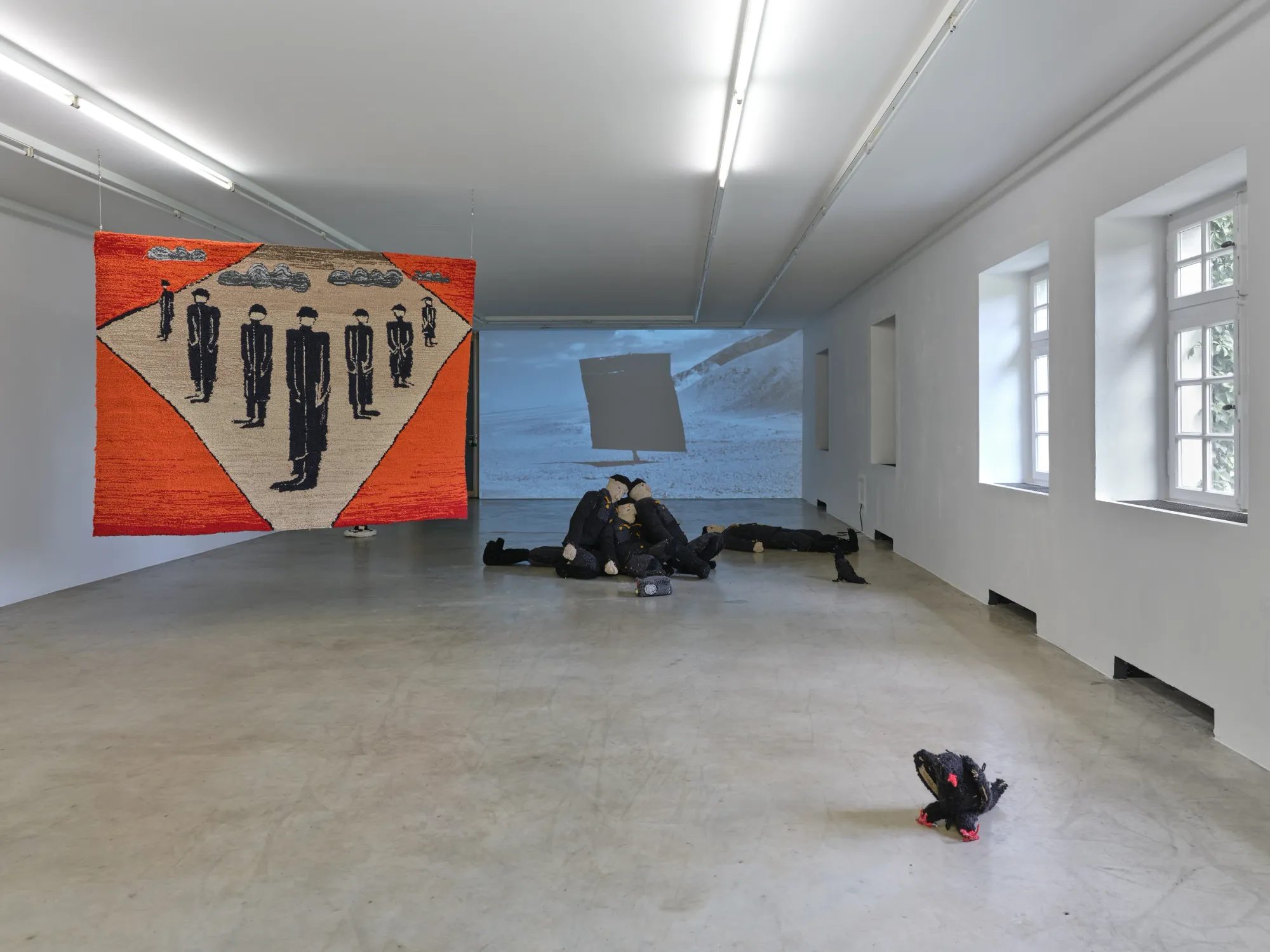 Elen Braga, Ich bin wie du, NAK Neuer Aachener Kunstverein, Aachen, 2026, uniformed fabric soldiers facing large red-white-black tapestry Winter in Germany